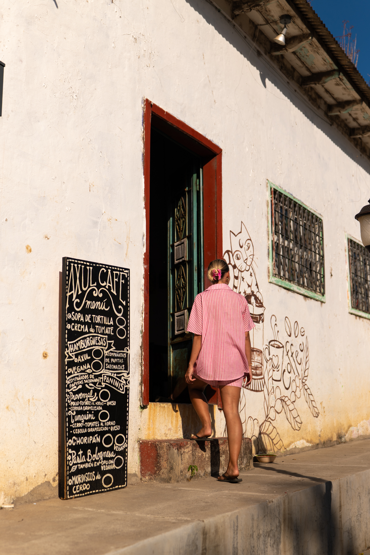 Person entering Azul Café in Juayúa along the colorful Ruta de las Flores street