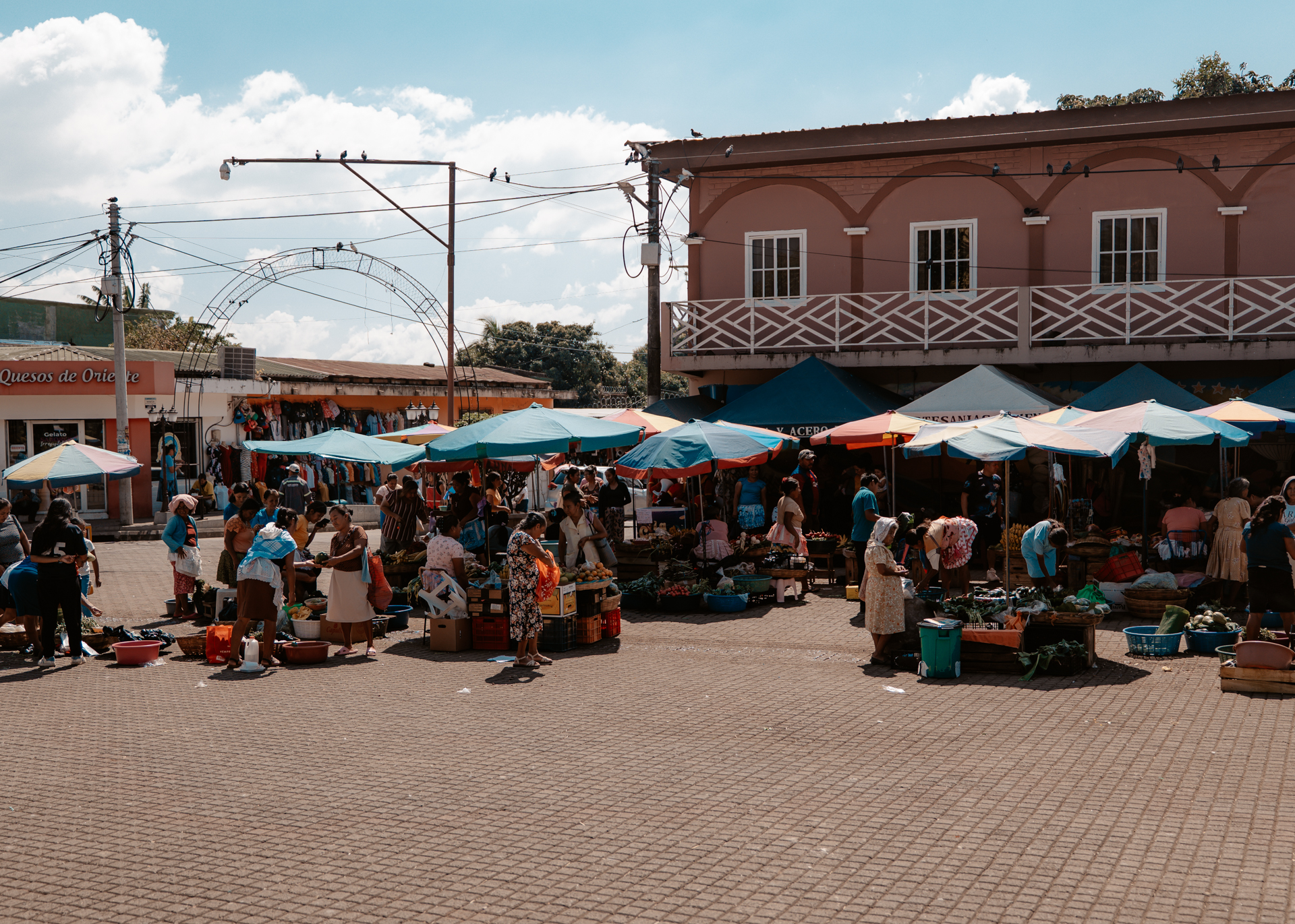 Local market with colorful umbrellas and vendors selling produce in Nahuizalco on El Salvador’s Ruta de las Flores