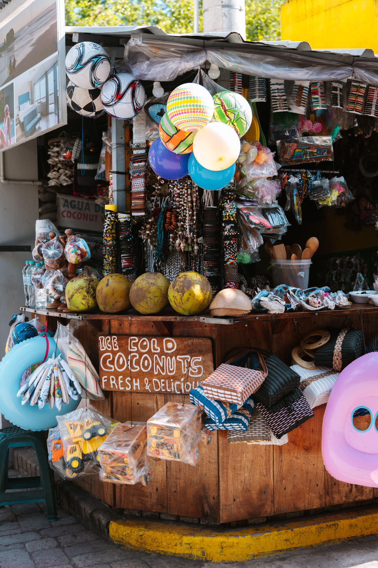 Colorful street stall in El Tunco selling coconuts, souvenirs, and beach toys in El Salvador.
