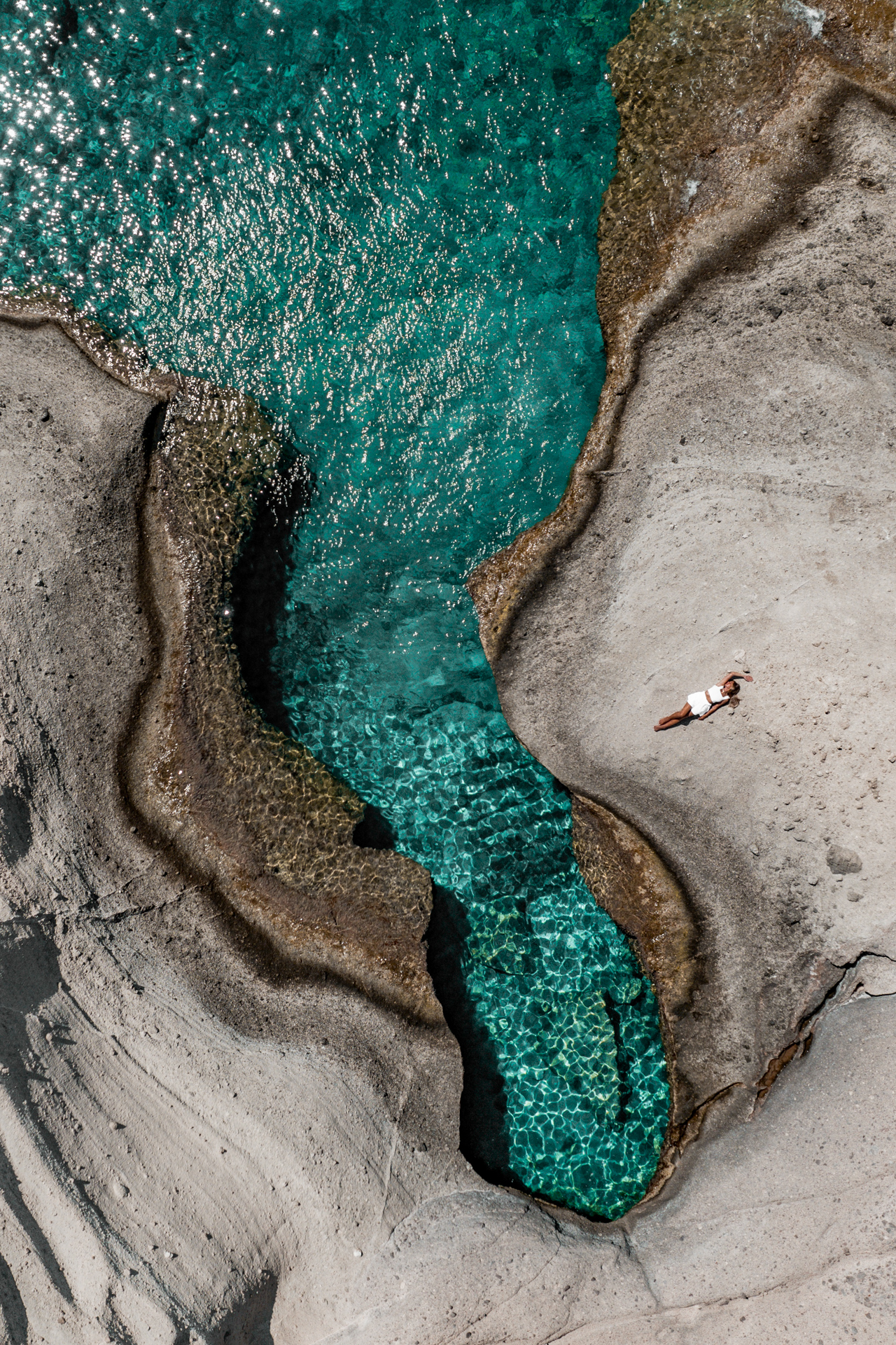 Aerial view of turquoise rock pool in Antiparos, Greece coastline
