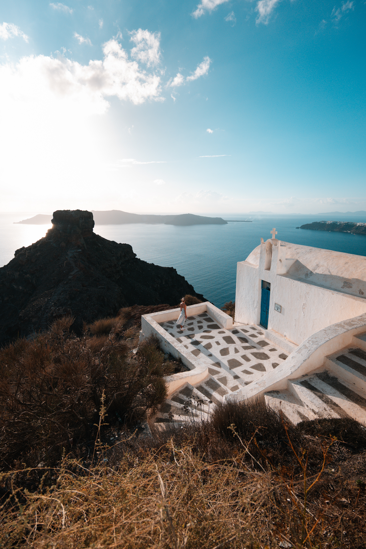Small white chapel overlooking Santorini caldera and Skaros Rock for sunset