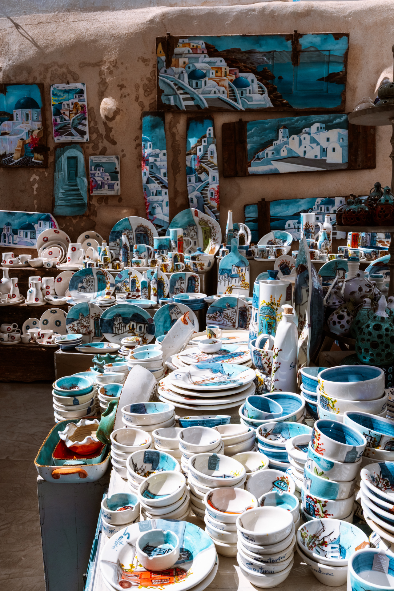 Colorful handmade pottery and souvenirs in Santorini market with iconic Greek designs