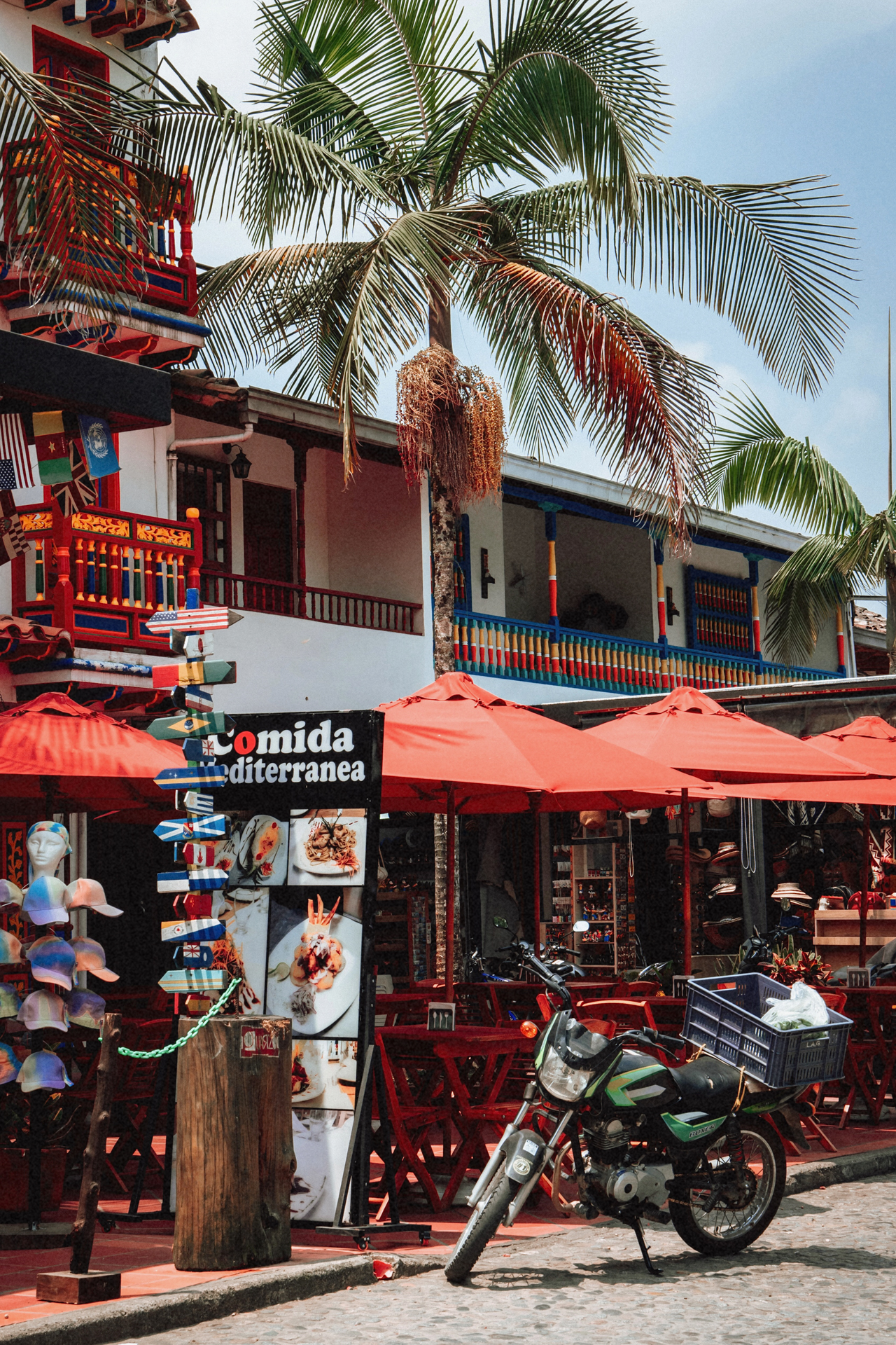 Colorful Guatape street with palm trees, cafes and vibrant colonial architecture