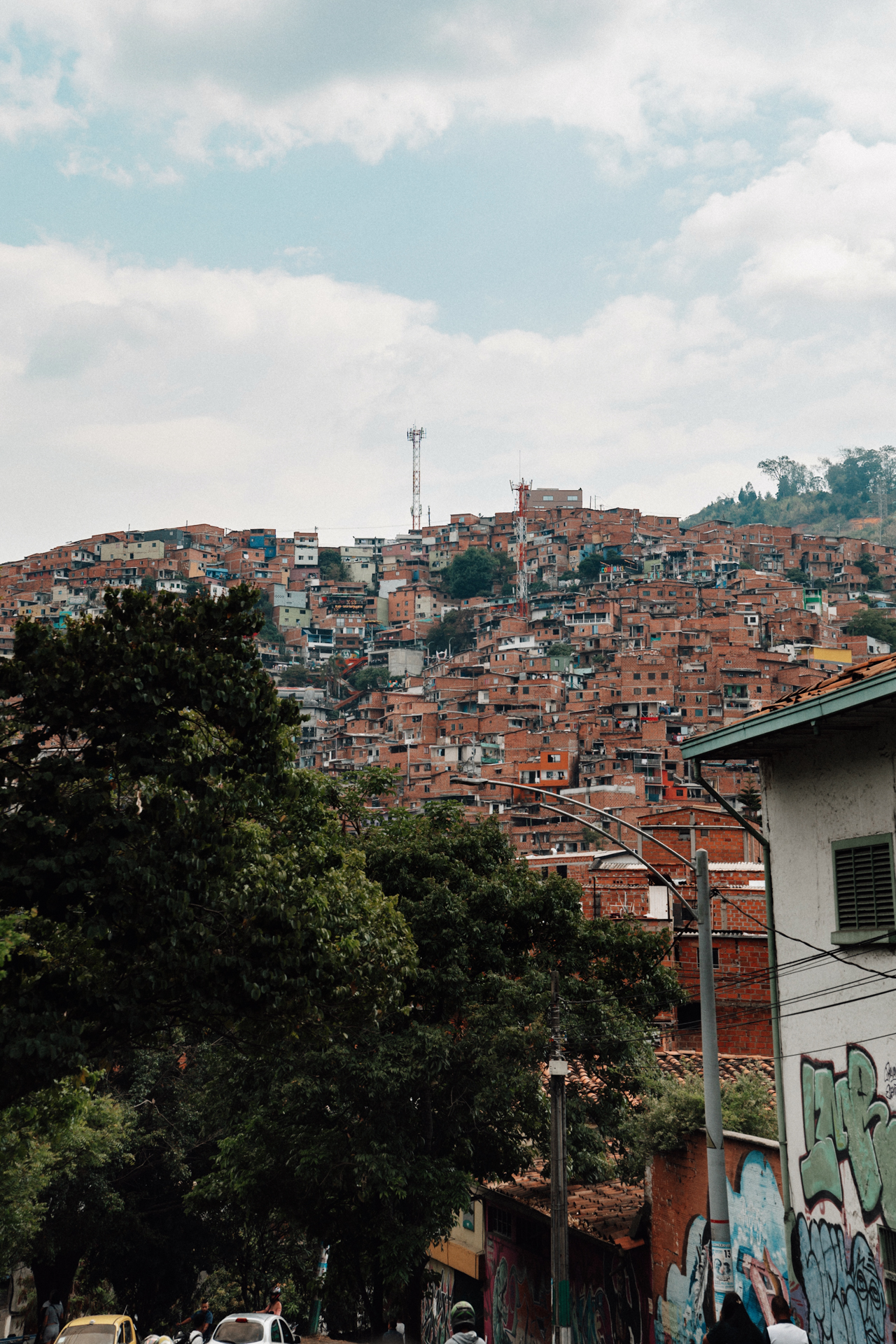 Medellin hillside barrio with dense brick houses of Communa 13 under cloudy sky