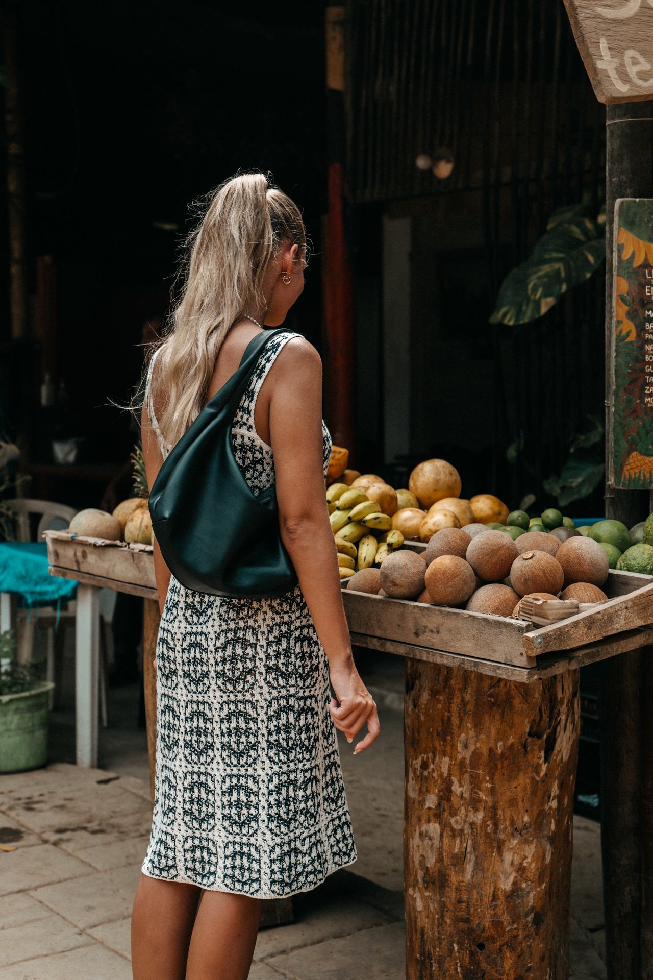 Woman exploring Palomino fruit stand with tropical market vibes