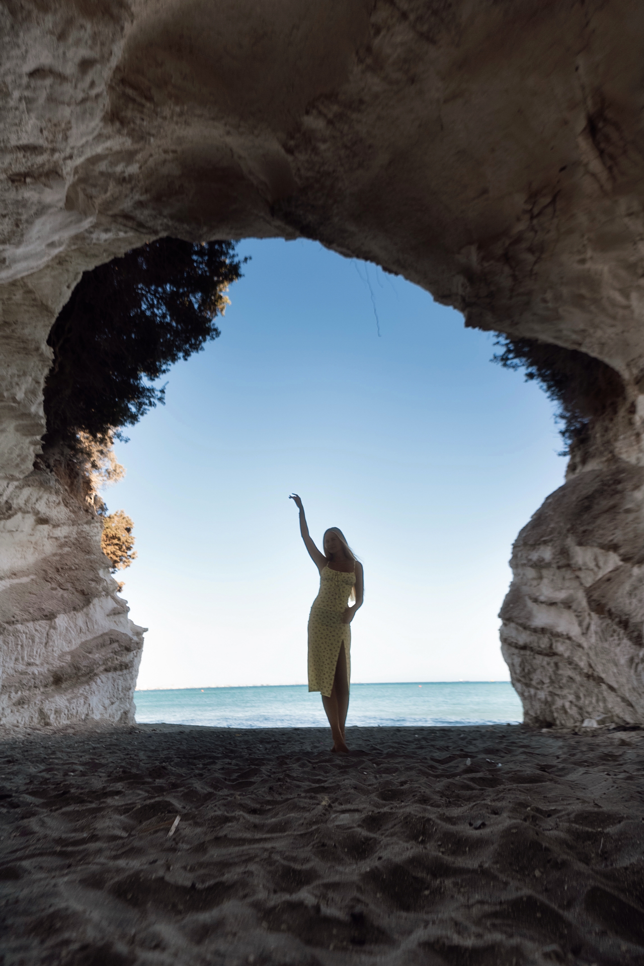 Woman standing inside sea cave with ocean view, Cyprus at Governor's Beach