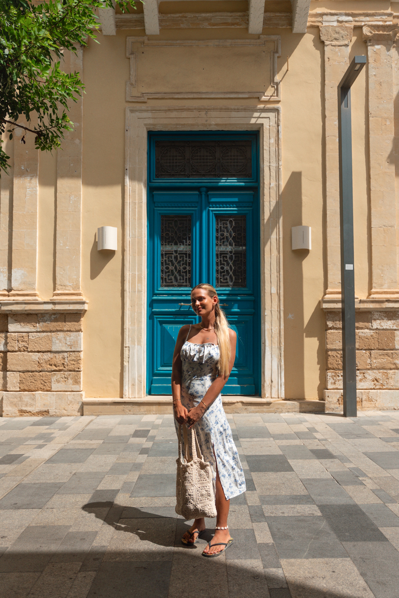 Woman standing in front of turquoise door in Paphos old town, Cyprus