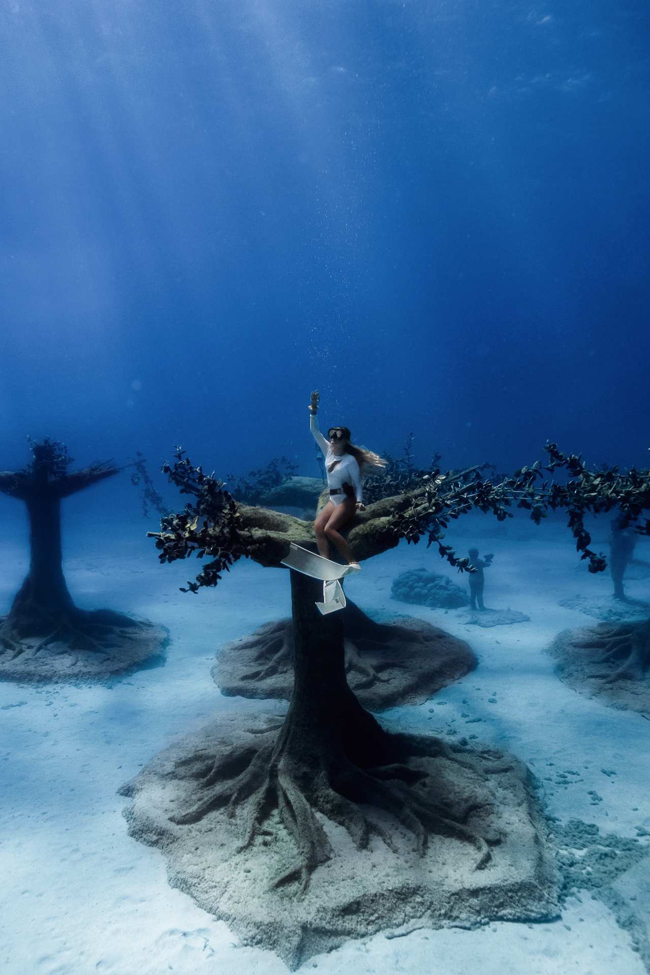 Freediver resting on underwater tree sculpture at MUSAN, Cyprus