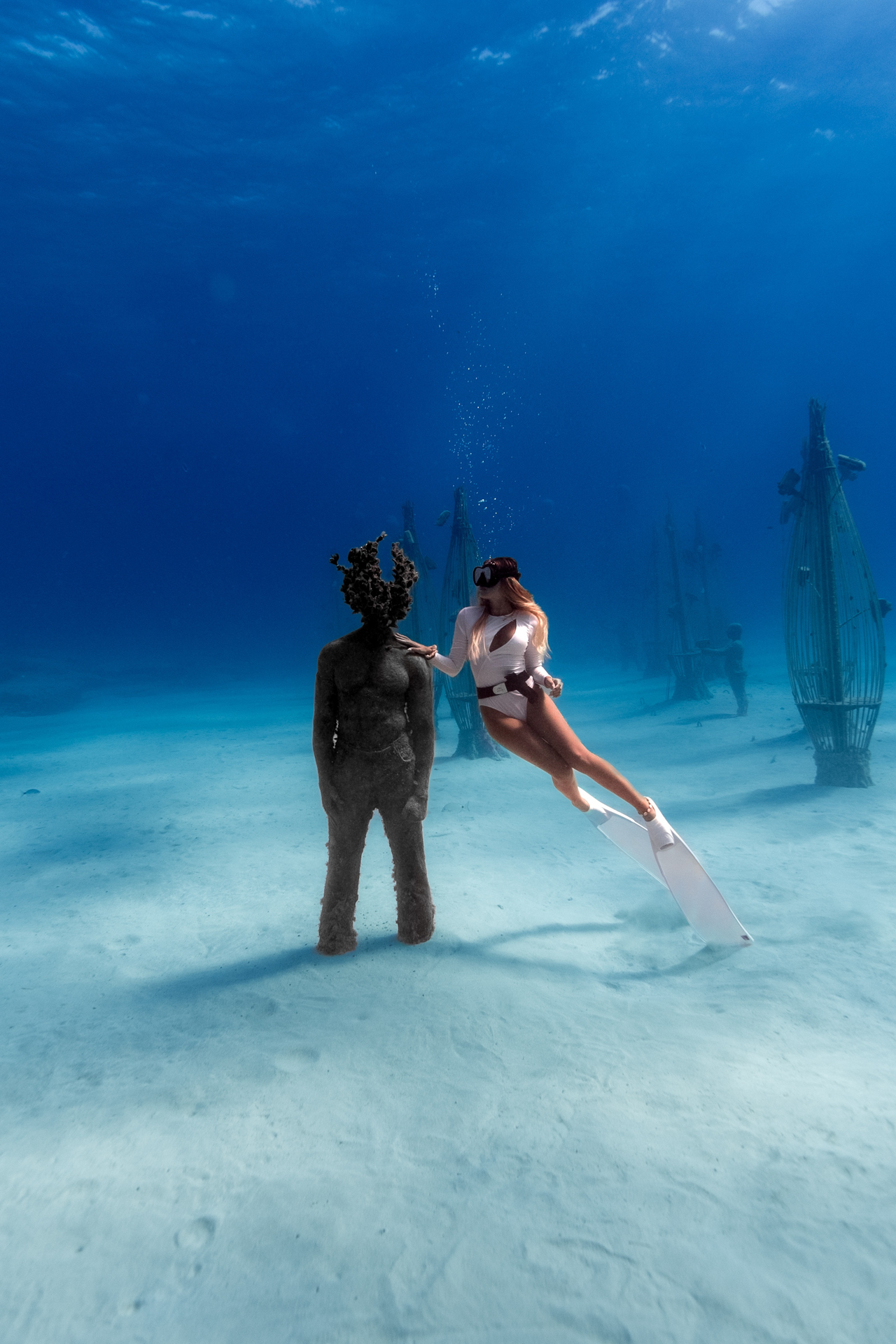 Freediver interacting with statue at MUSAN underwater museum, Cyprus