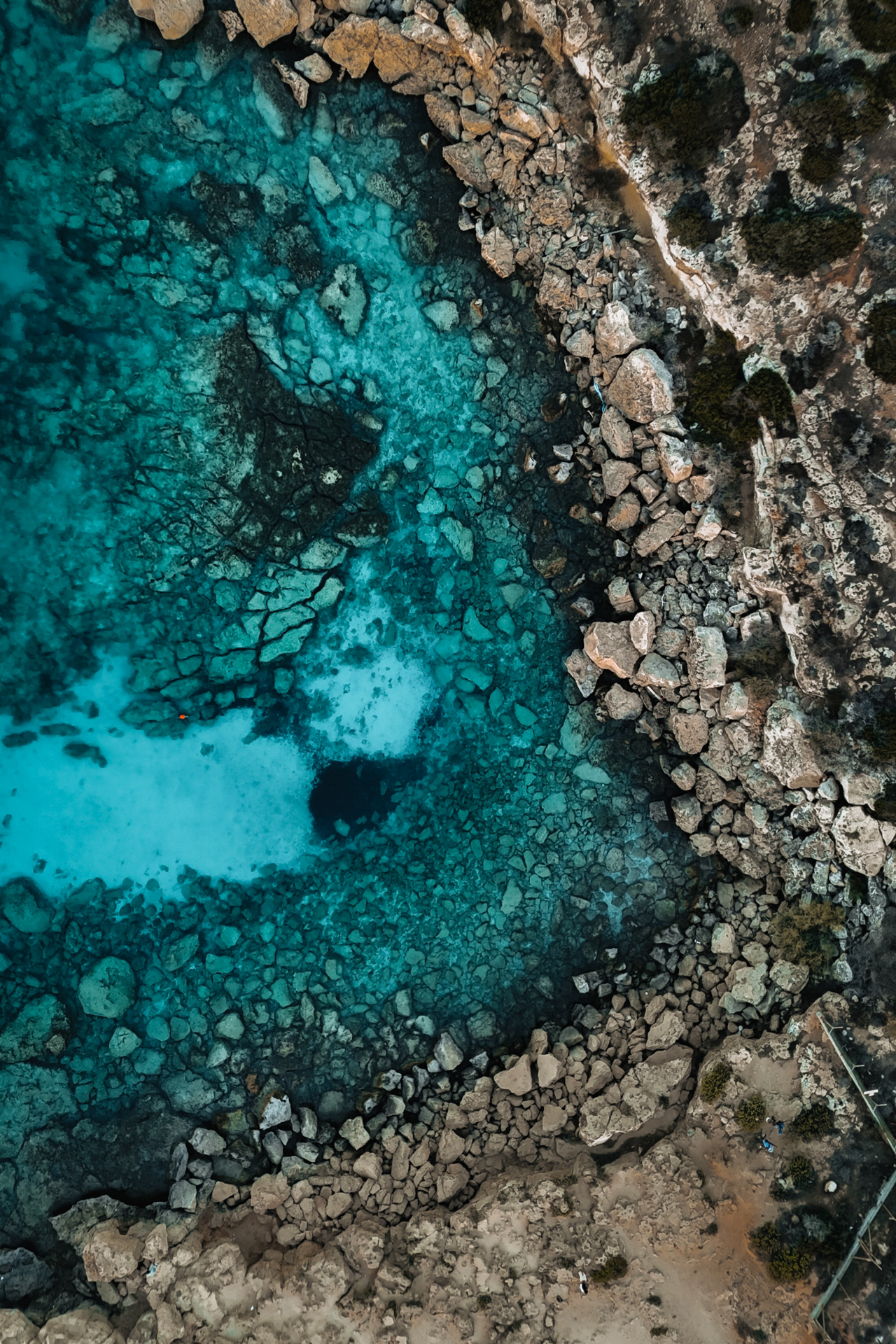Aerial view of turquoise water and rocky coastline at Cape Greco, Cyprus