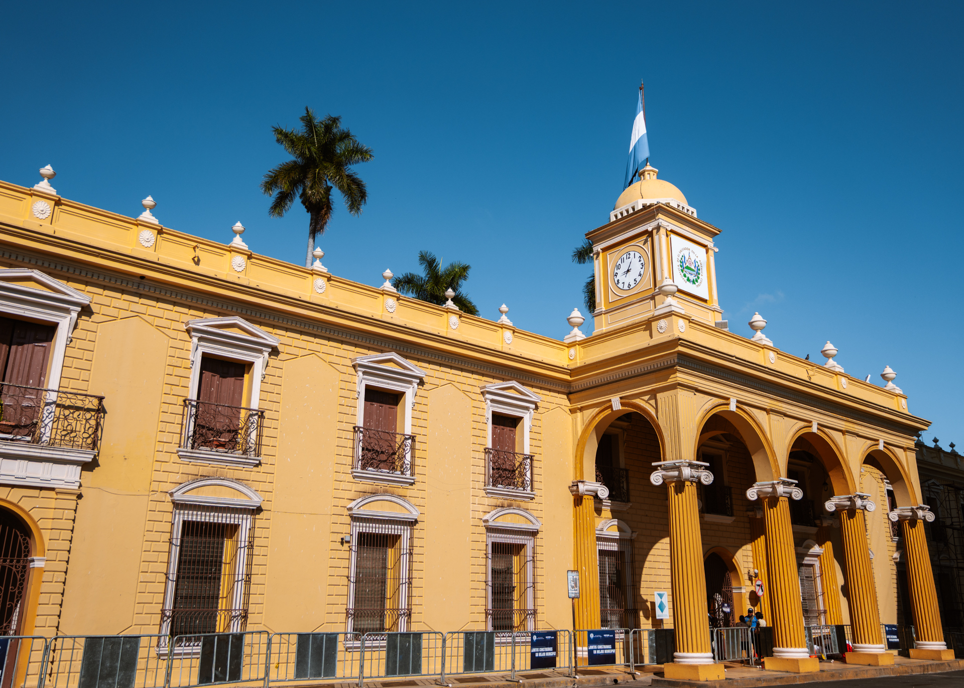 Yellow colonial building with clock tower in Santa Ana under a clear blue sky