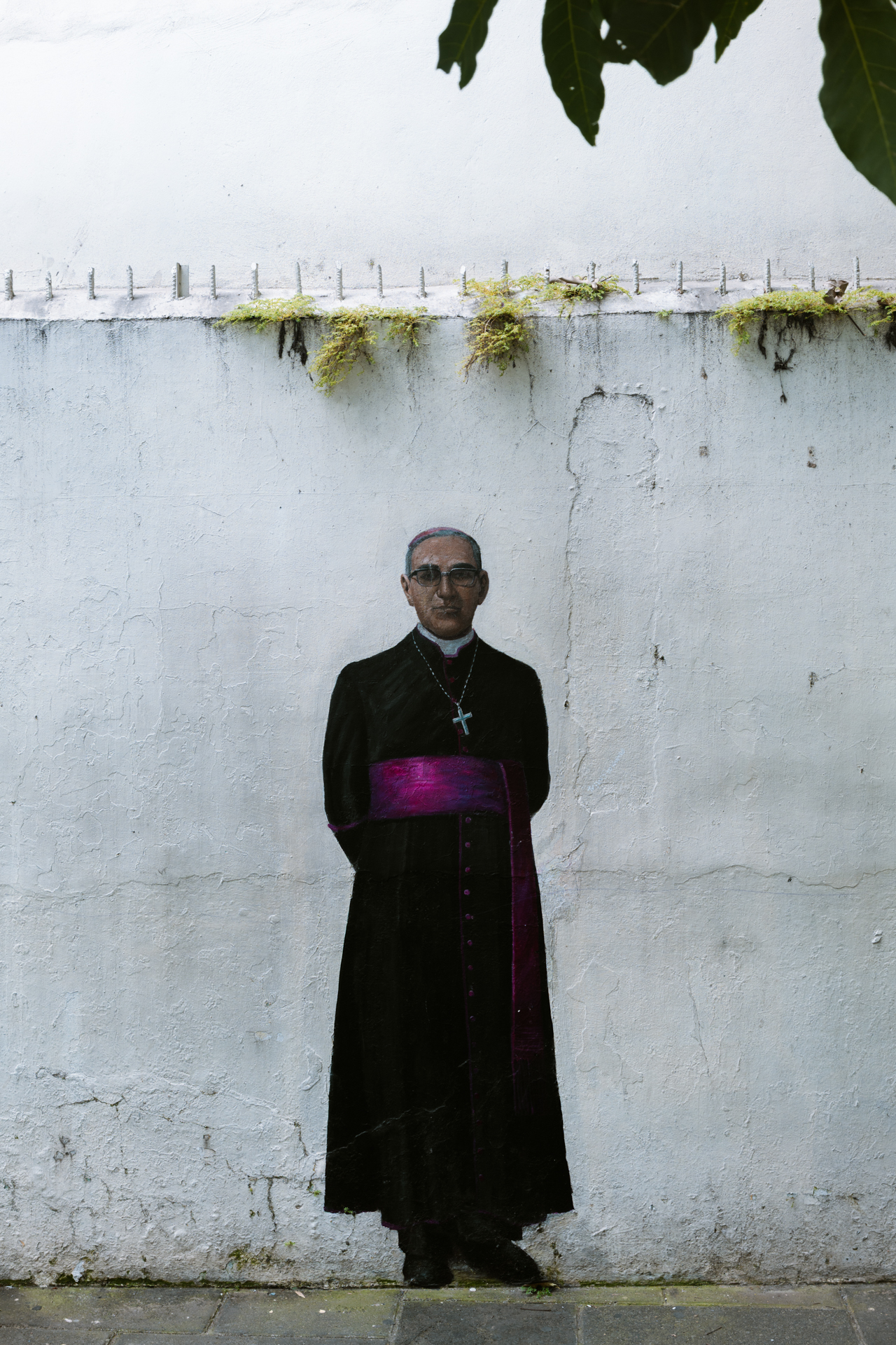 Mural of Archbishop Óscar Romero painted on a white wall in San Salvador
