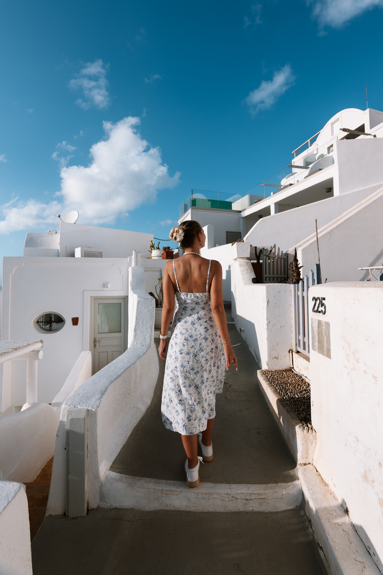 Woman walking in Imerovigli Santorini with white architecture and narrow streets