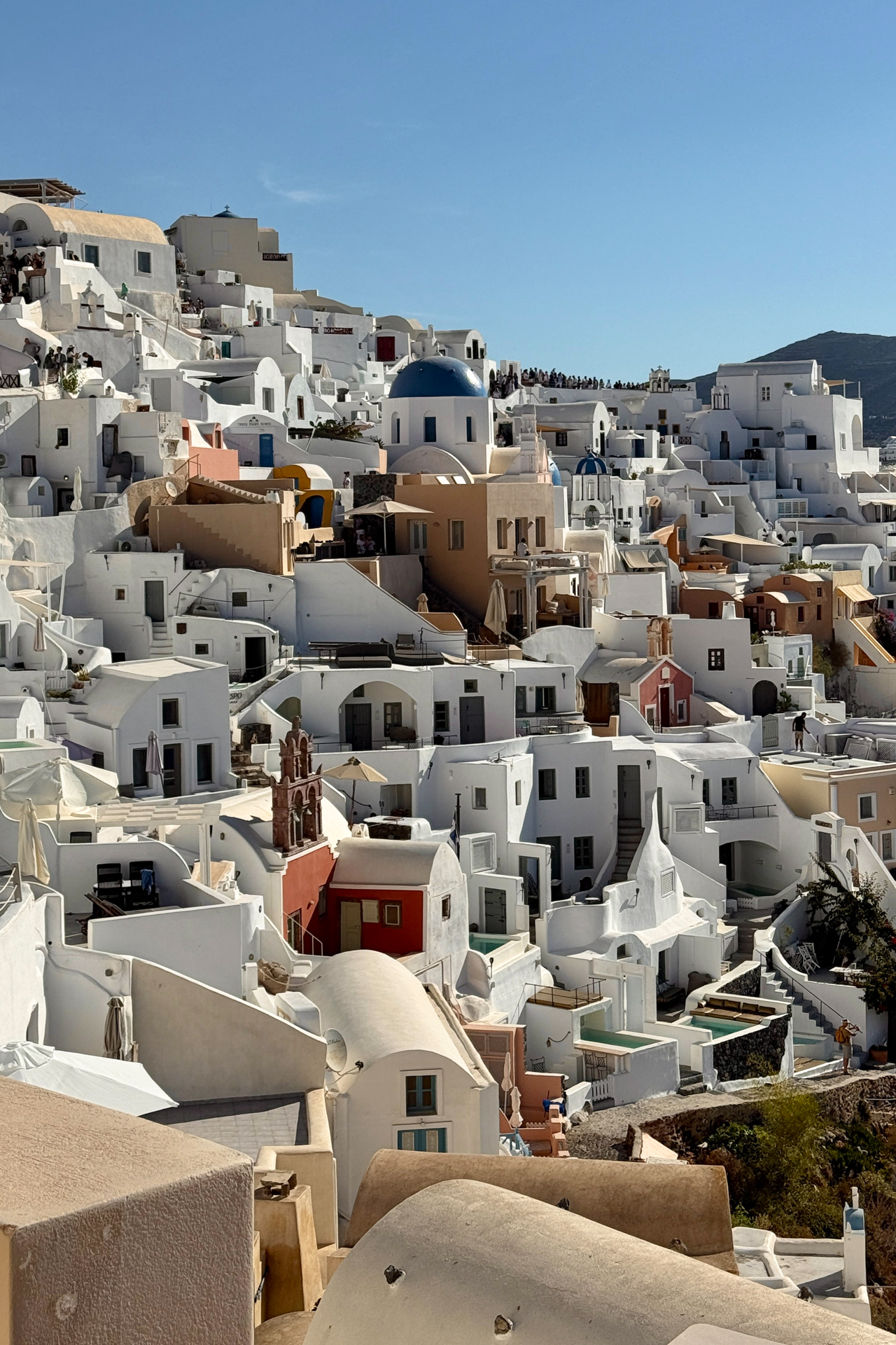 Whitewashed houses cascading down Oia cliffs in Santorini, Greece