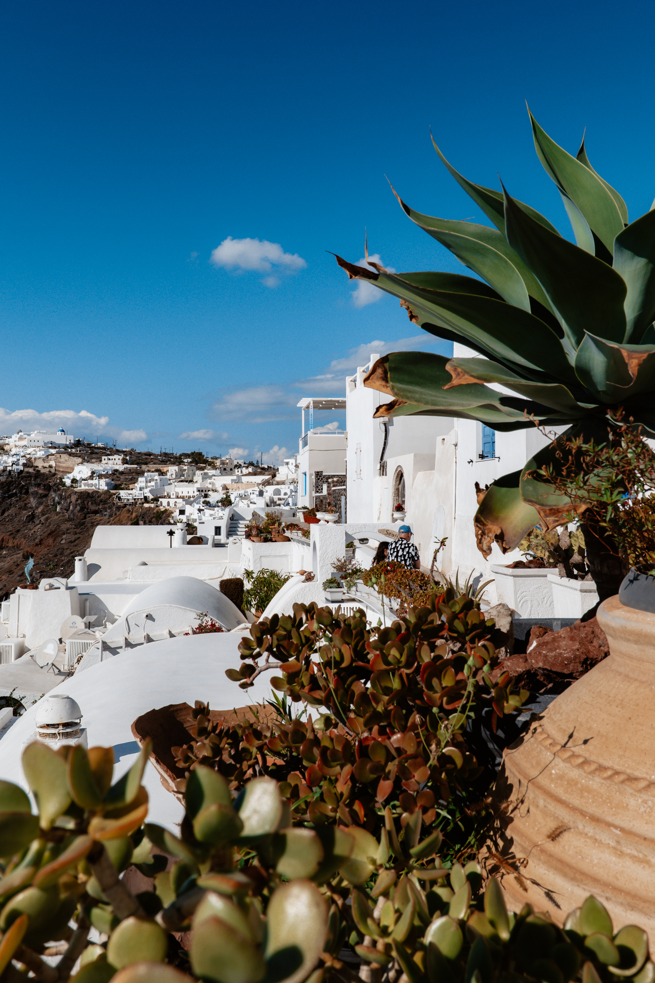 Whitewashed houses of Santorini cascading along a cliff in Oia.