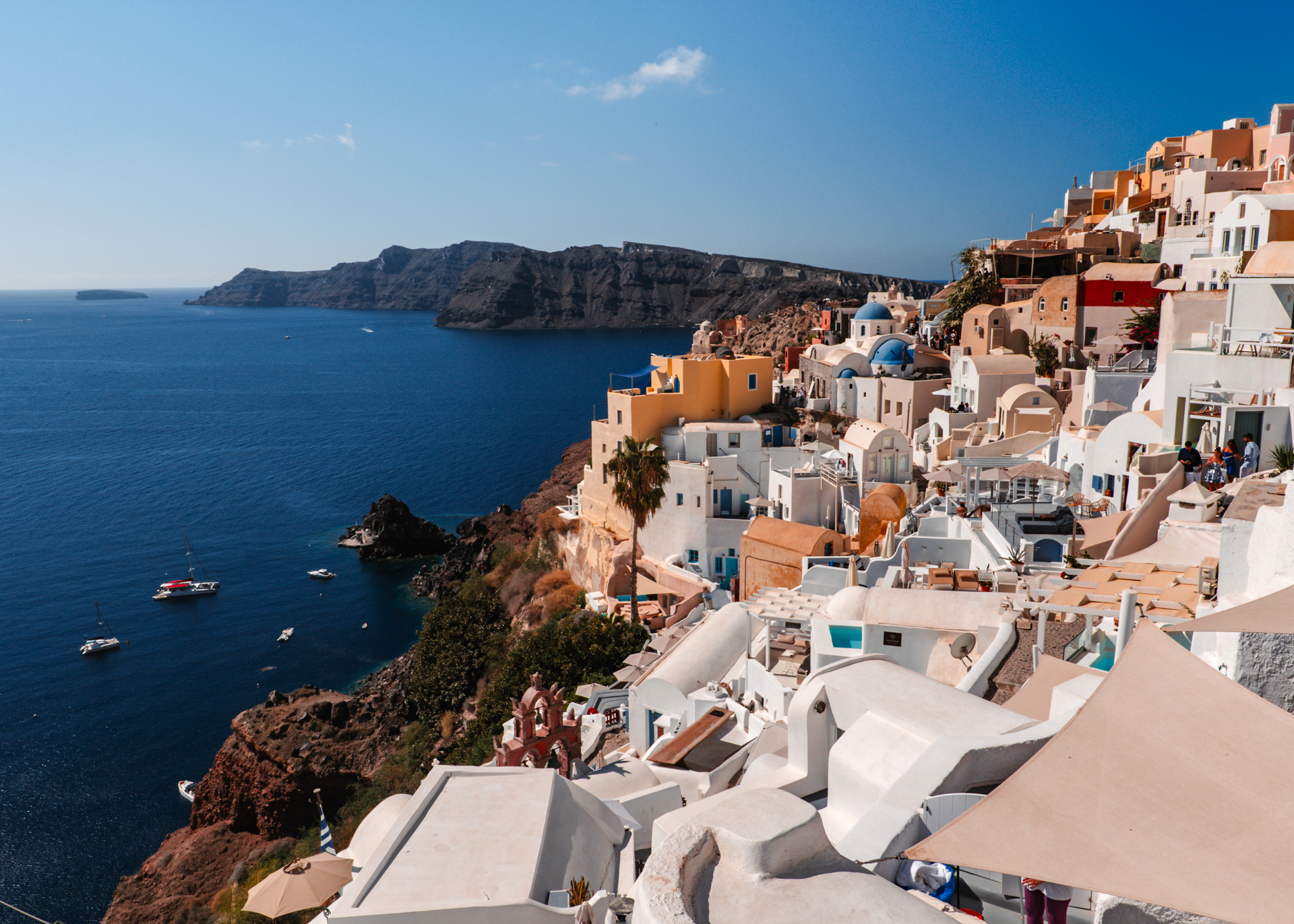 Oia Santorini with white houses, blue domes and caldera view over Aegean Sea