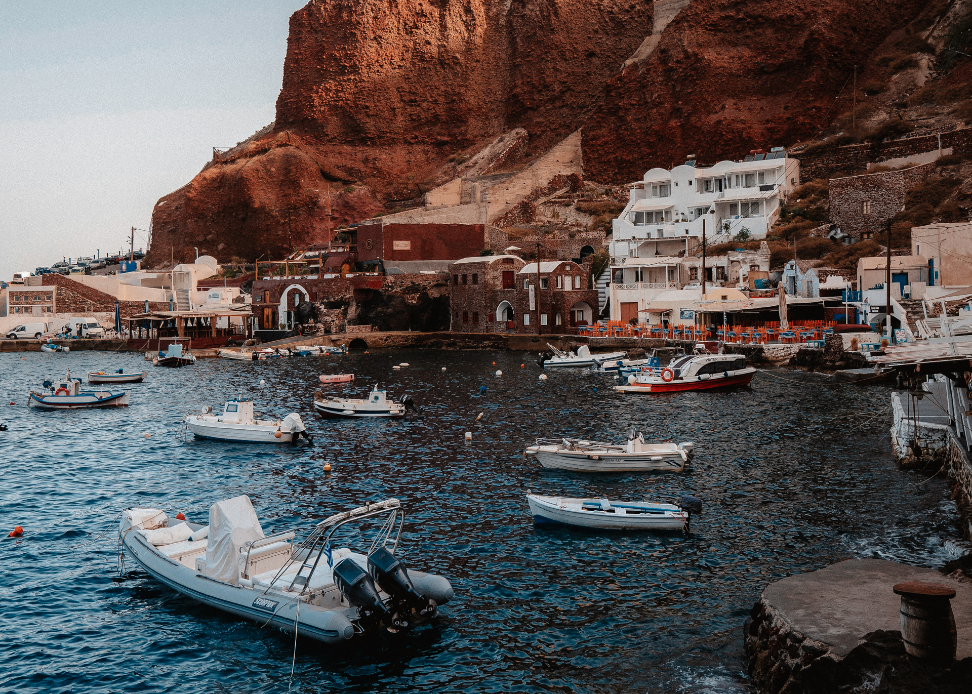Ammoudi Bay Santorini with fishing boats, waterfront tavernas and red volcanic cliffs