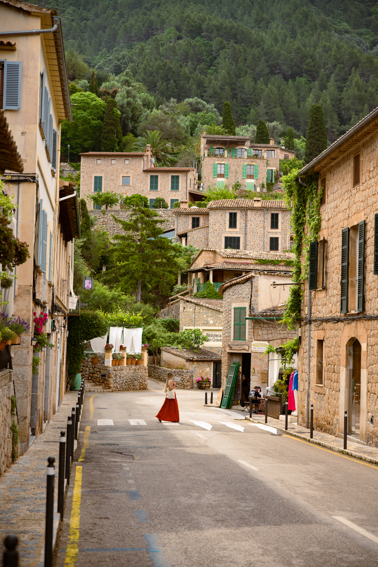 Quiet street in Deià village with stone houses and mountain backdrop, Mallorca, Spain