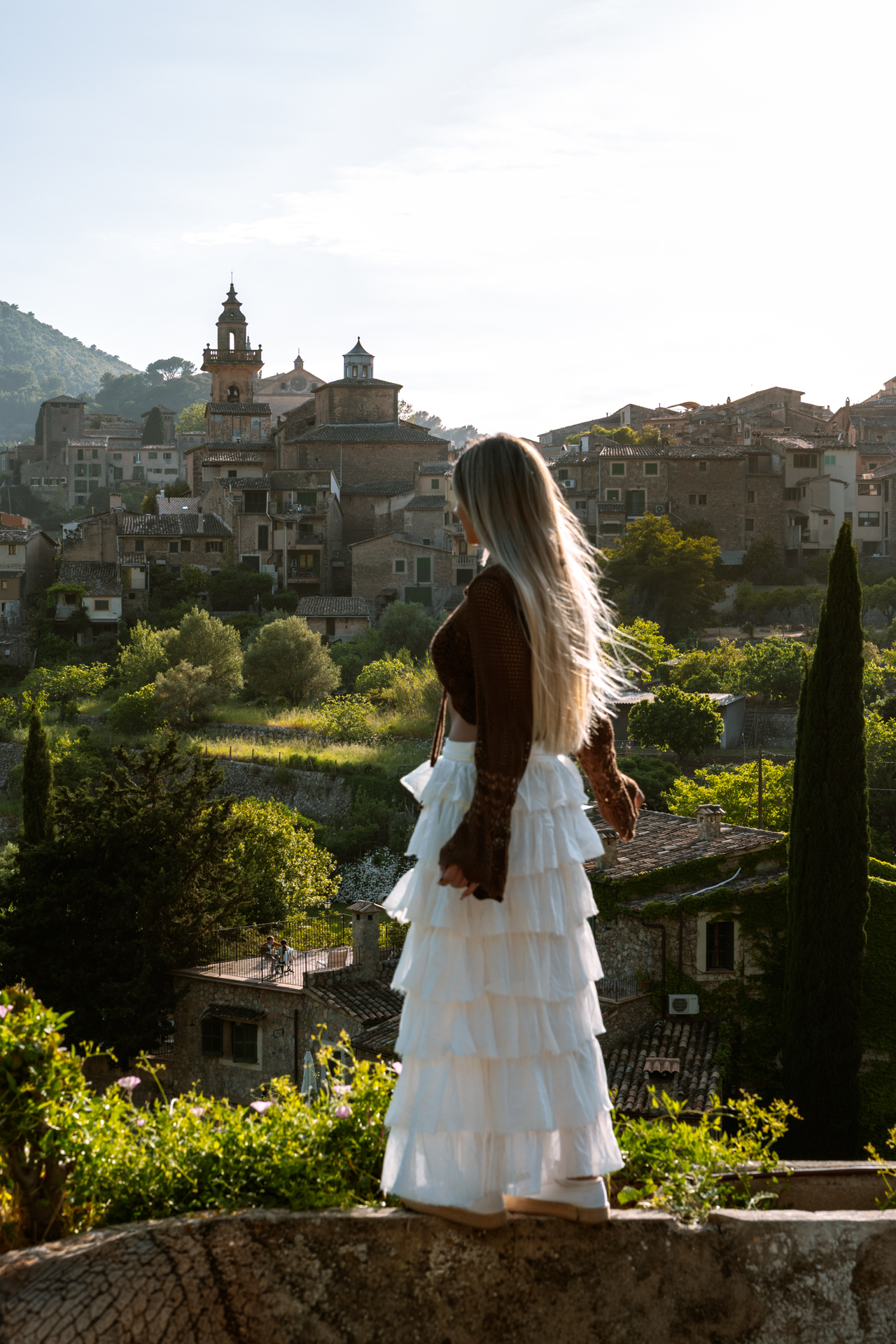 Woman overlooking Valldemossa village at golden hour in Mallorca, Spain