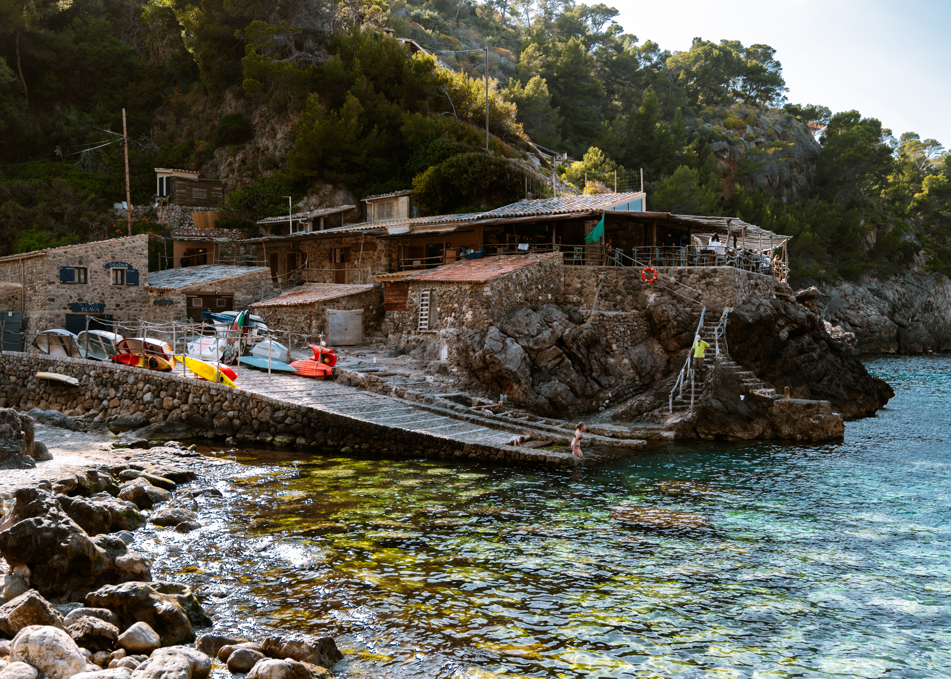 Cala Deià waterfront in Mallorca with turquoise water and rustic stone houses