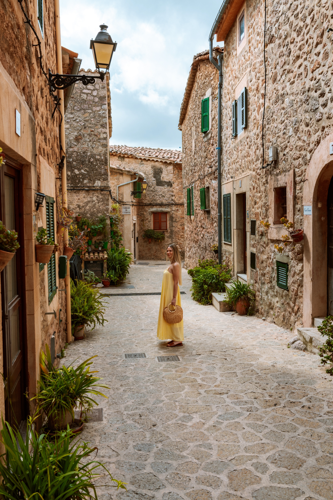 Woman walking through charming stone streets in Valldemossa, Mallorca