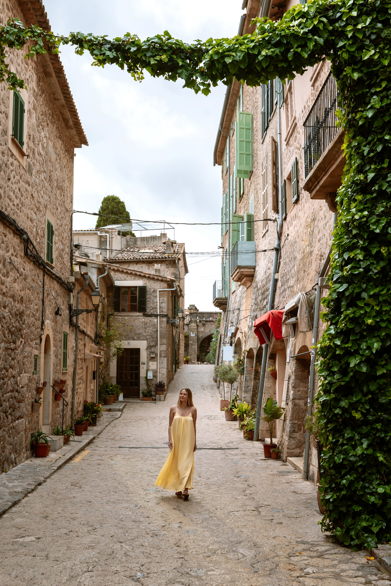 Woman walking through the charming stone streets of Valldemossa, Mallorca, Spain