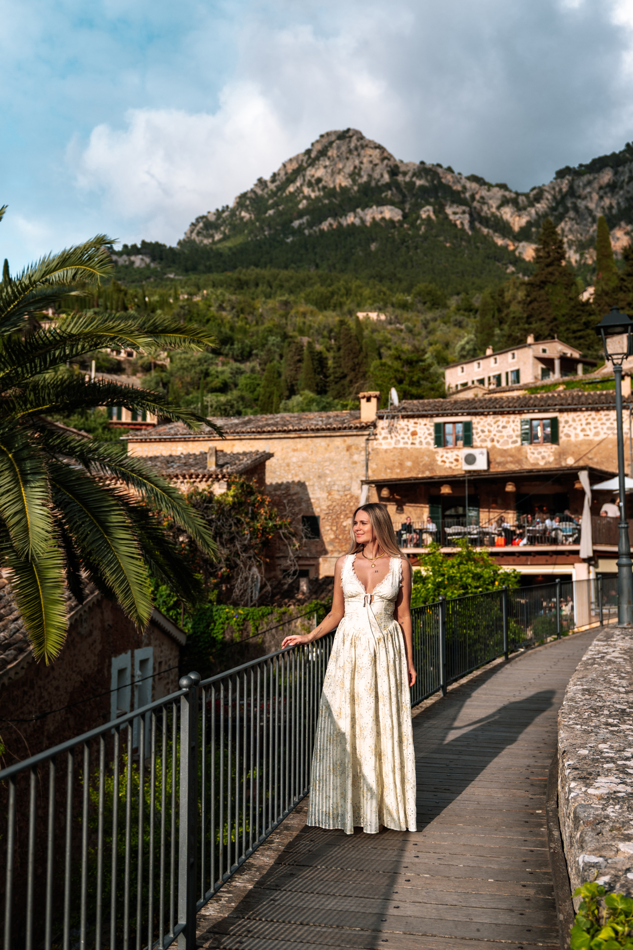 Woman on a scenic walkway in Deià with Tramuntana mountains in the background, Mallorca, Spain