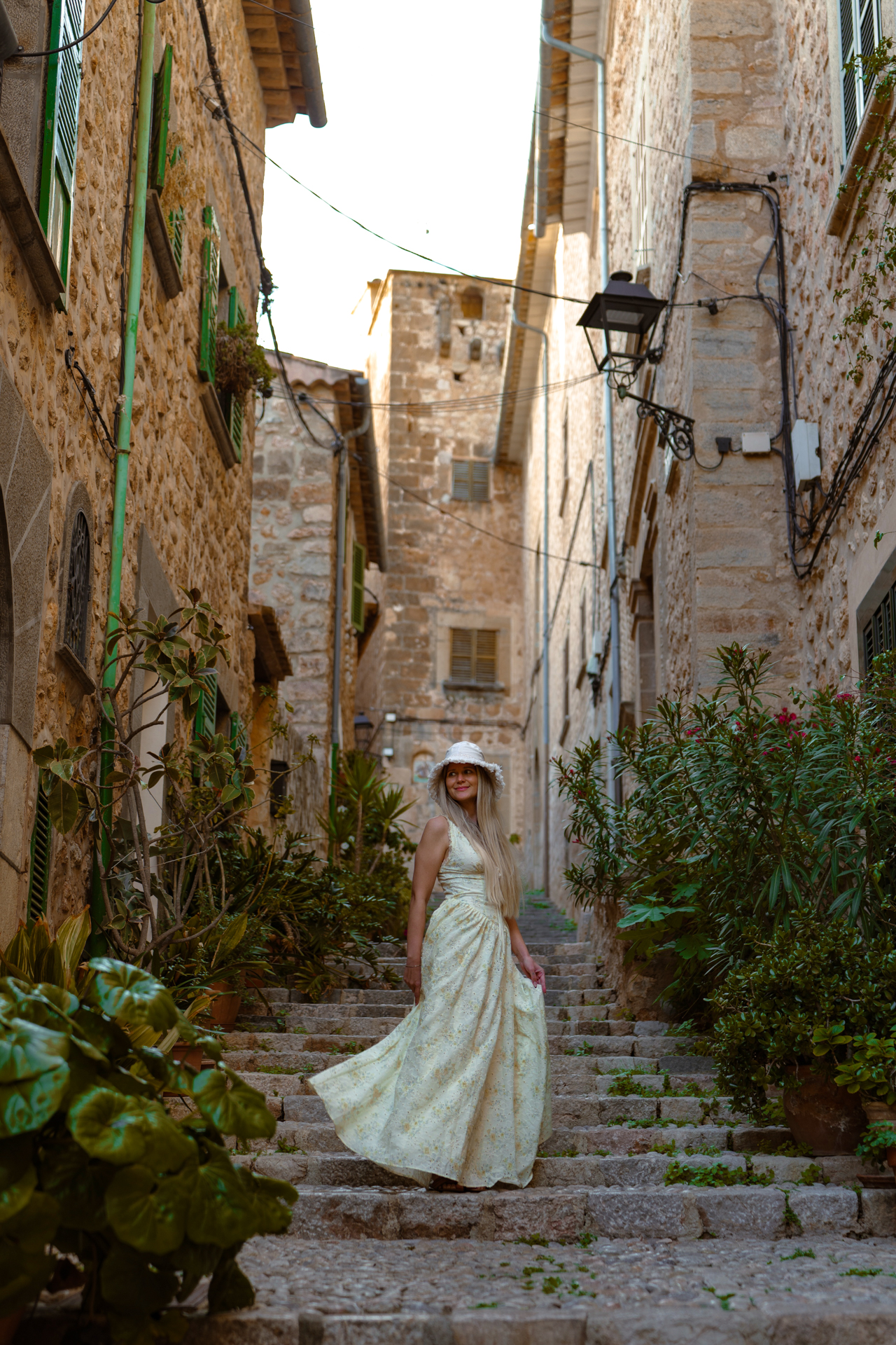Woman walking through a charming stone alley in Fornalutx, Mallorca, one of Spain’s most beautiful villages.