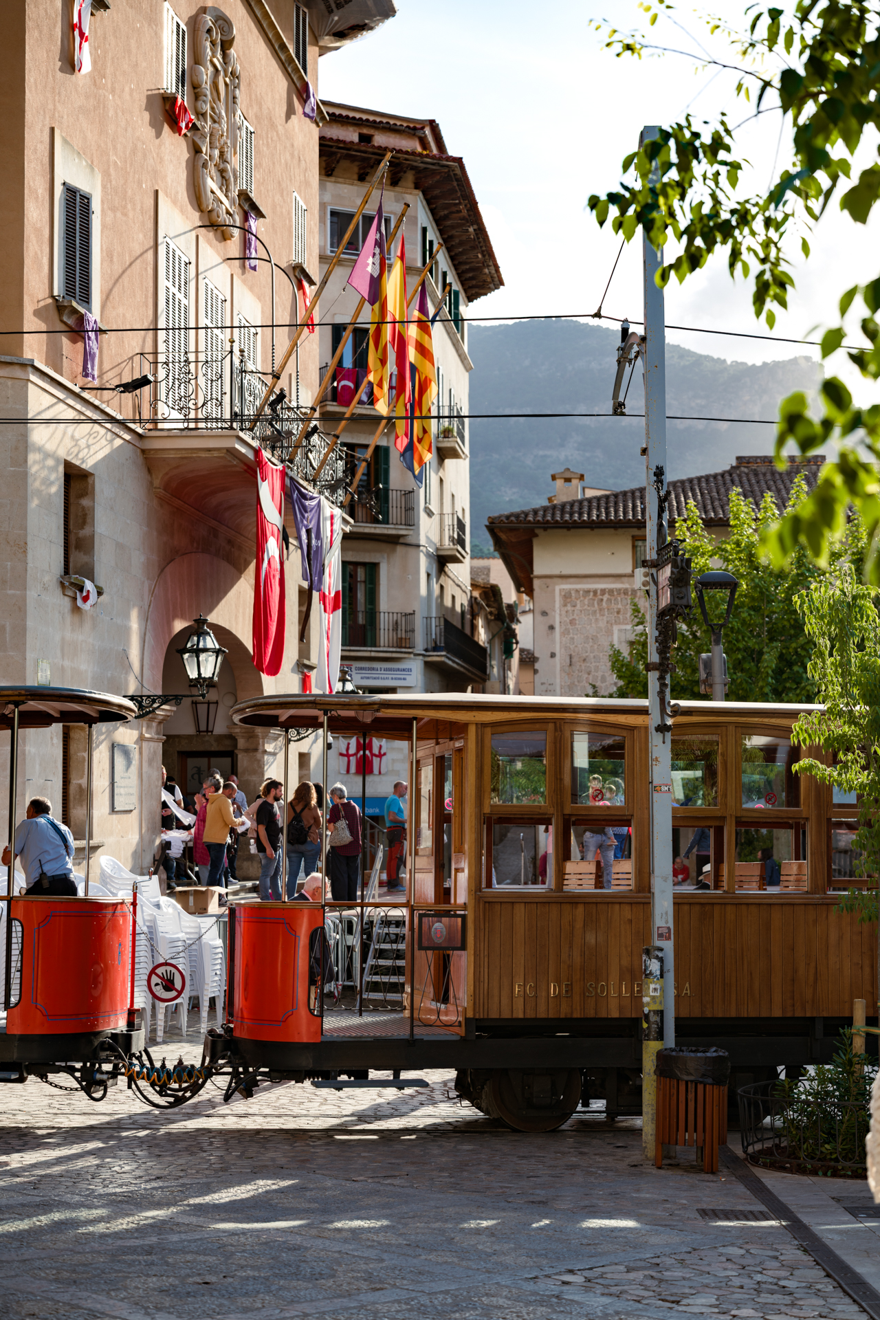 Historic Sóller tram passing through the town center in Sóller, Mallorca, surrounded by traditional architecture.