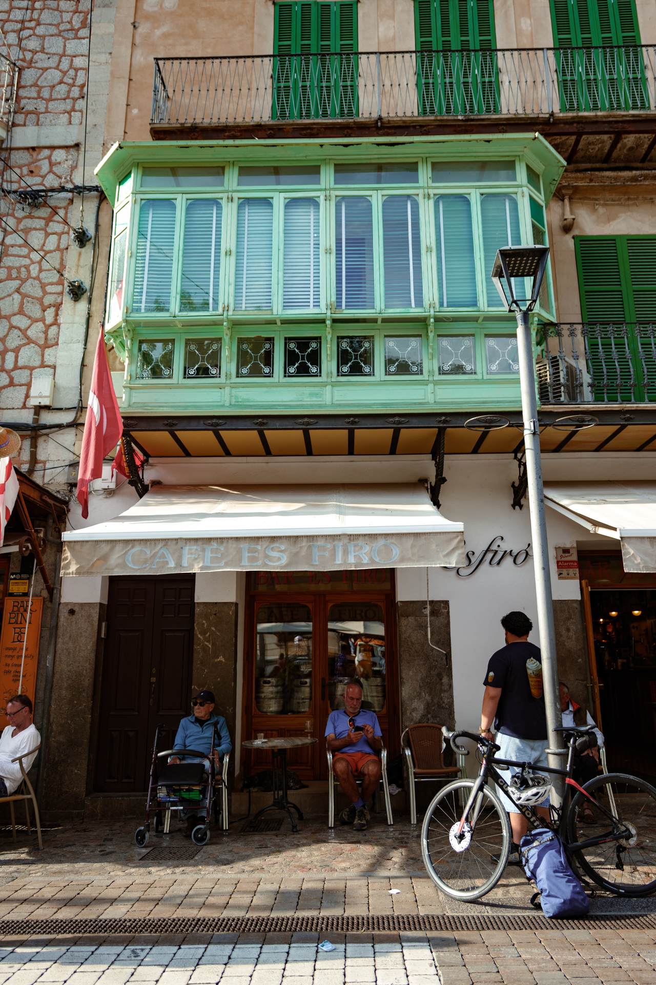 Traditional café and historic green balcony in the center of Sóller, Mallorca, showcasing local architecture and charm.