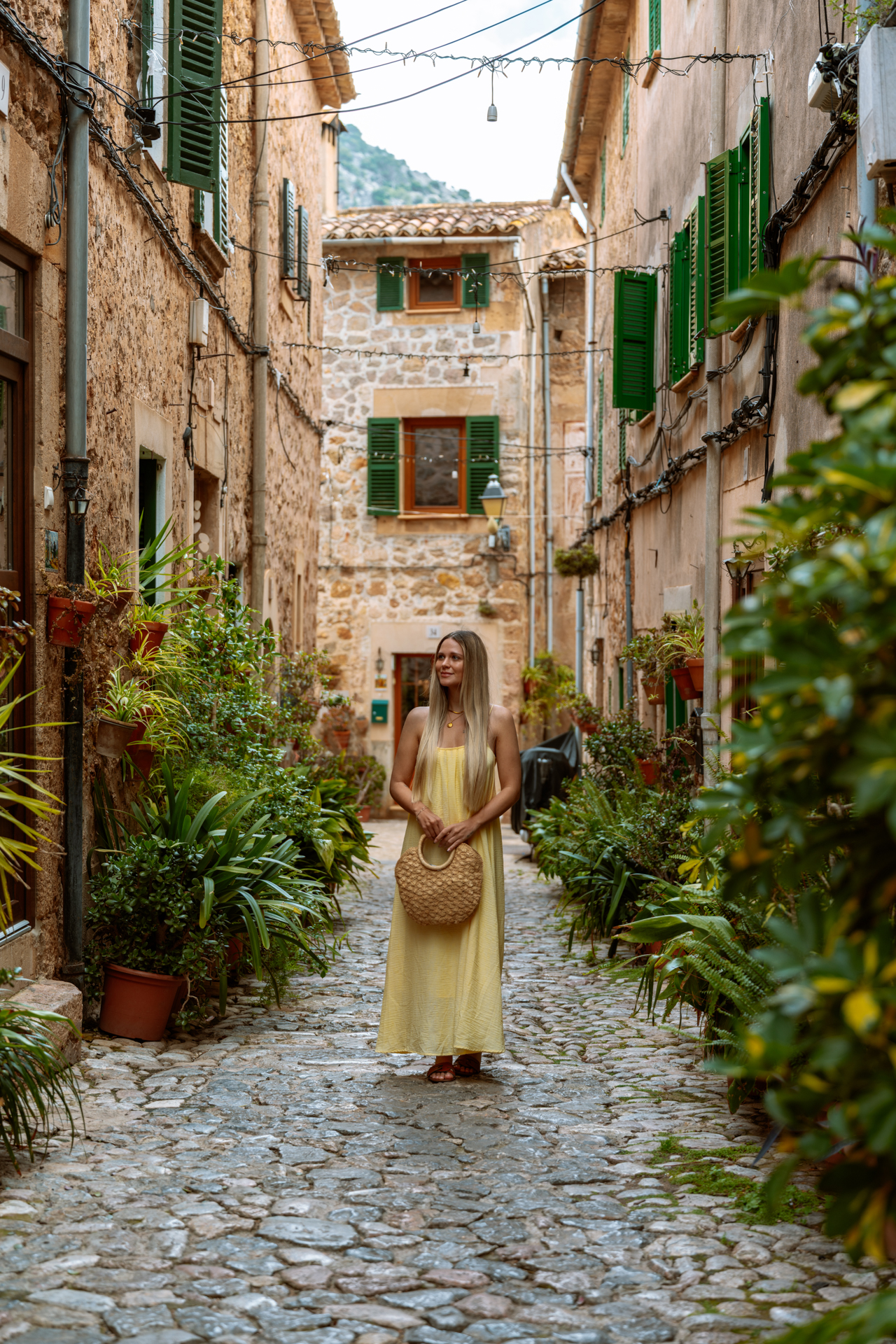 Woman on a charming cobblestone street in Valldemossa, Mallorca