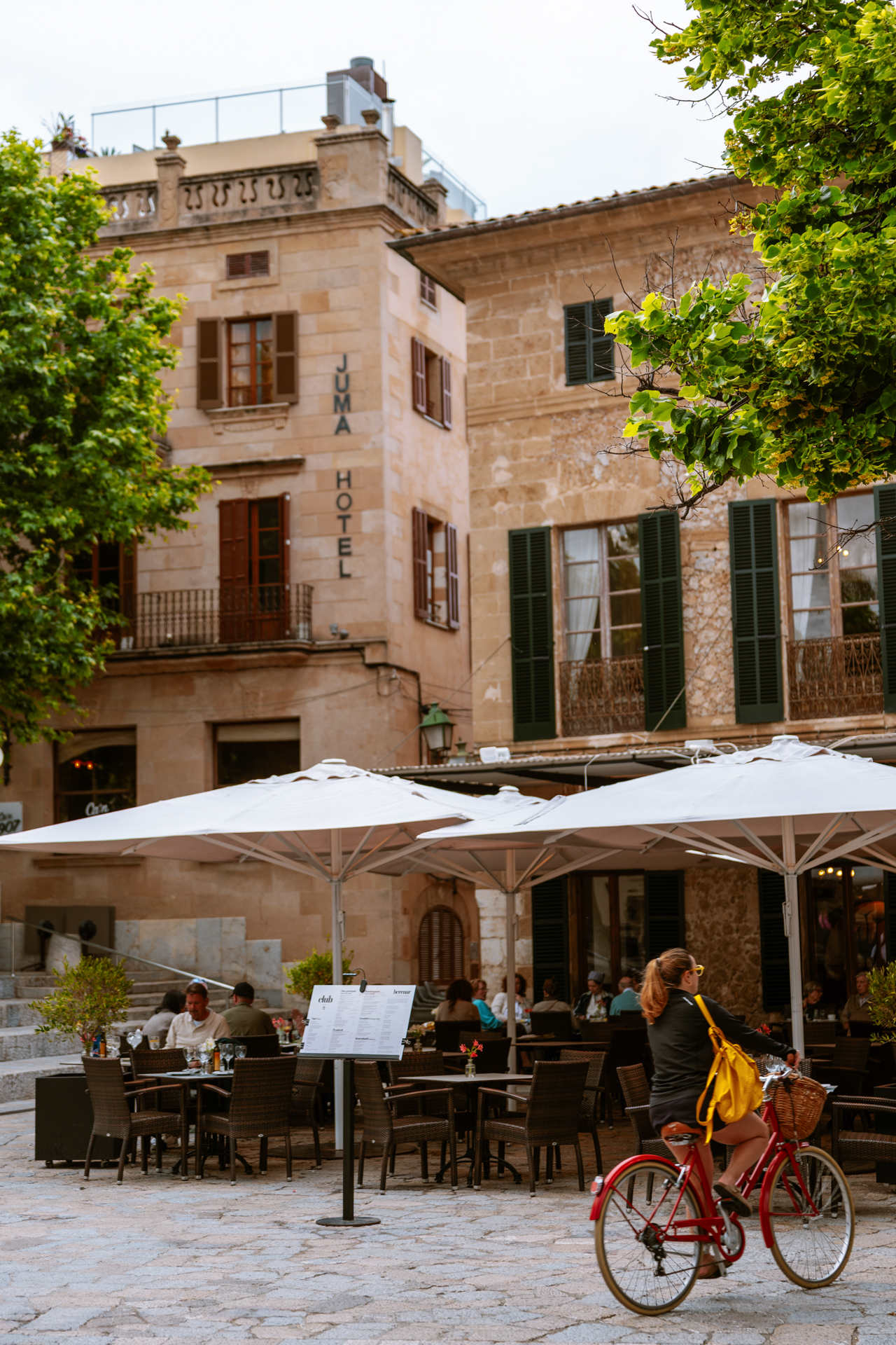 Pollença main square with cafés and historic stone buildings, Mallorca