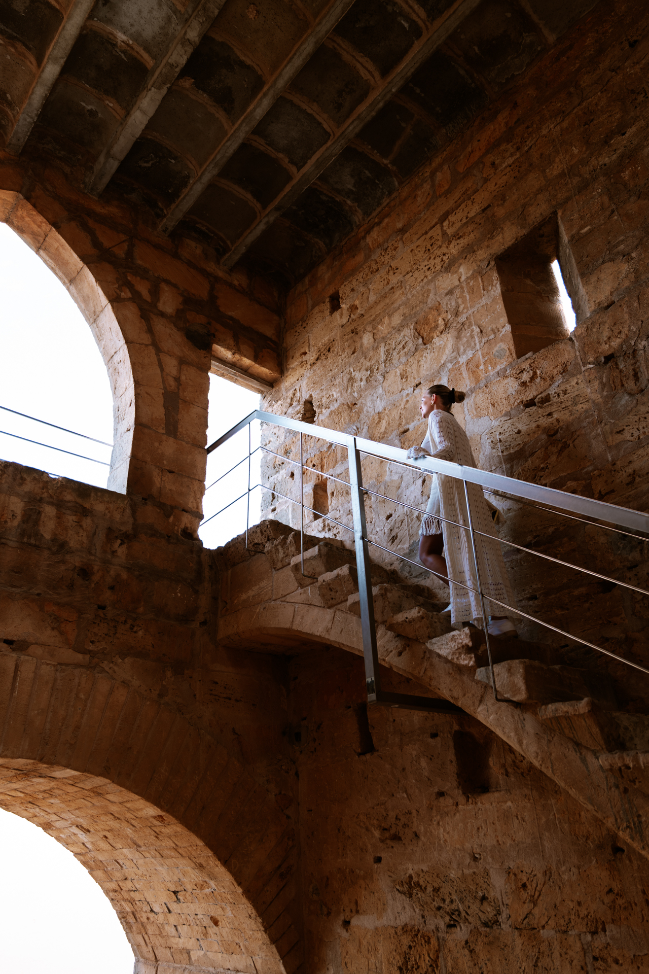 Woman walking along the medieval walls of Alcúdia Old Town in Mallorca.