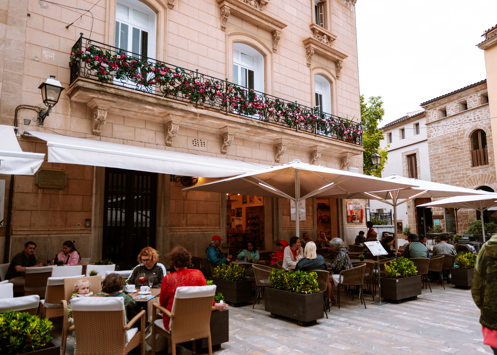 Outdoor cafés and historic buildings around Plaça de la Constitució in Alcúdia Old Town.