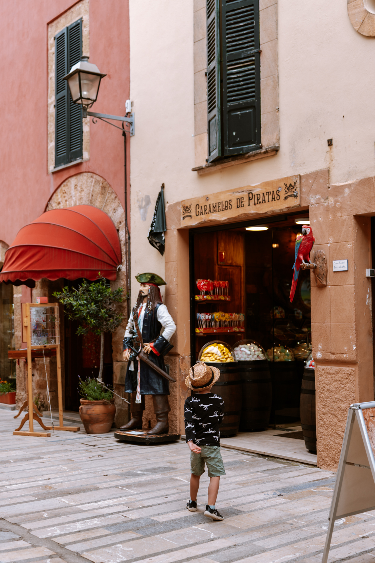 Child looking at a pirate-themed candy shop in Alcúdia Old Town, Mallorca.