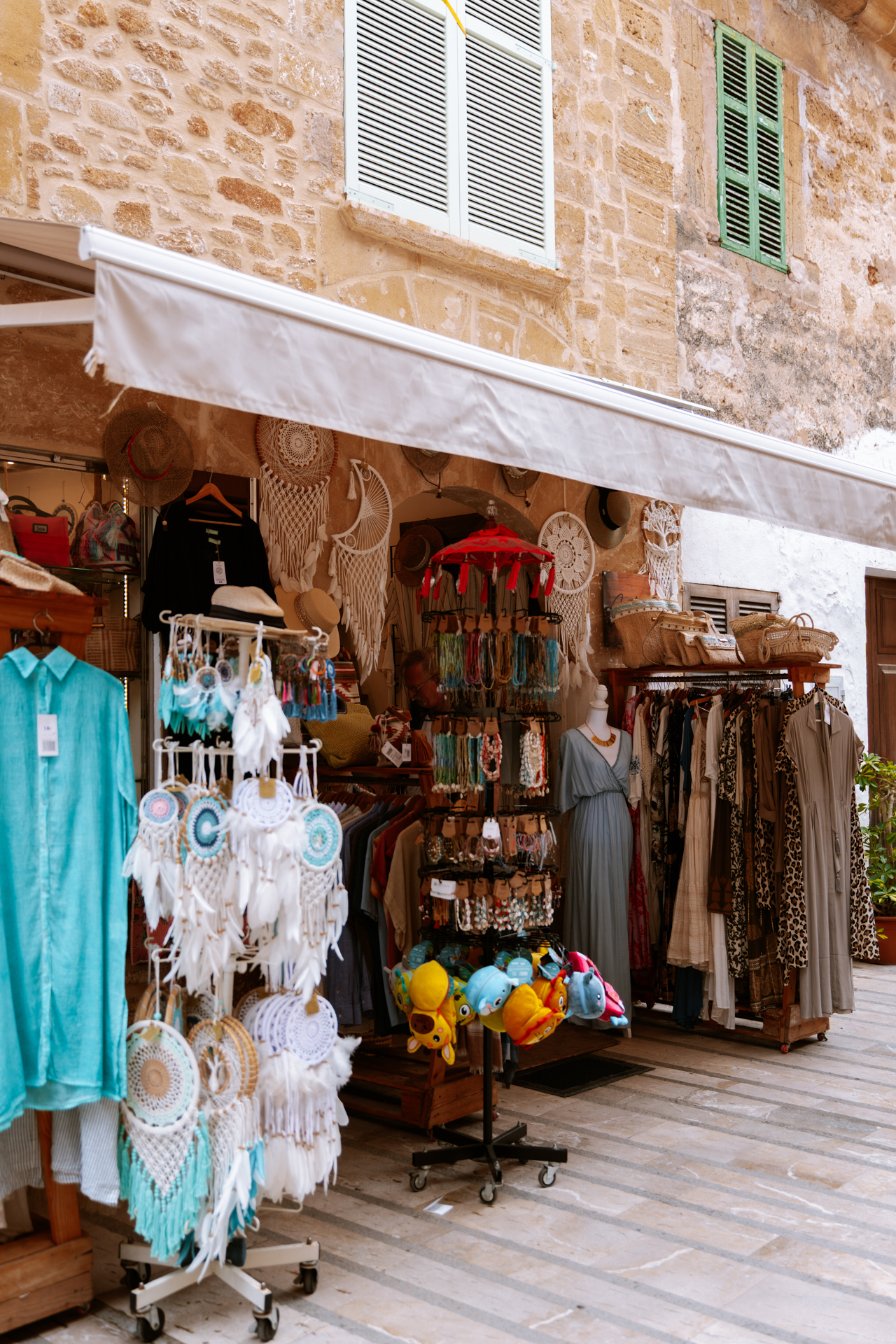 Colorful souvenir shop with clothing and accessories in Alcúdia Old Town, Mallorca.