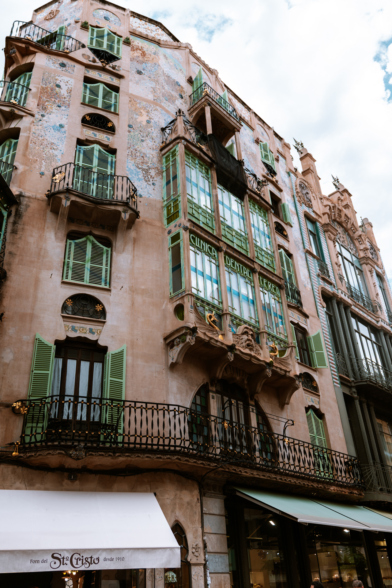 Art Nouveau building with green shutters and ornate balconies in Palma de Mallorca, Spain.