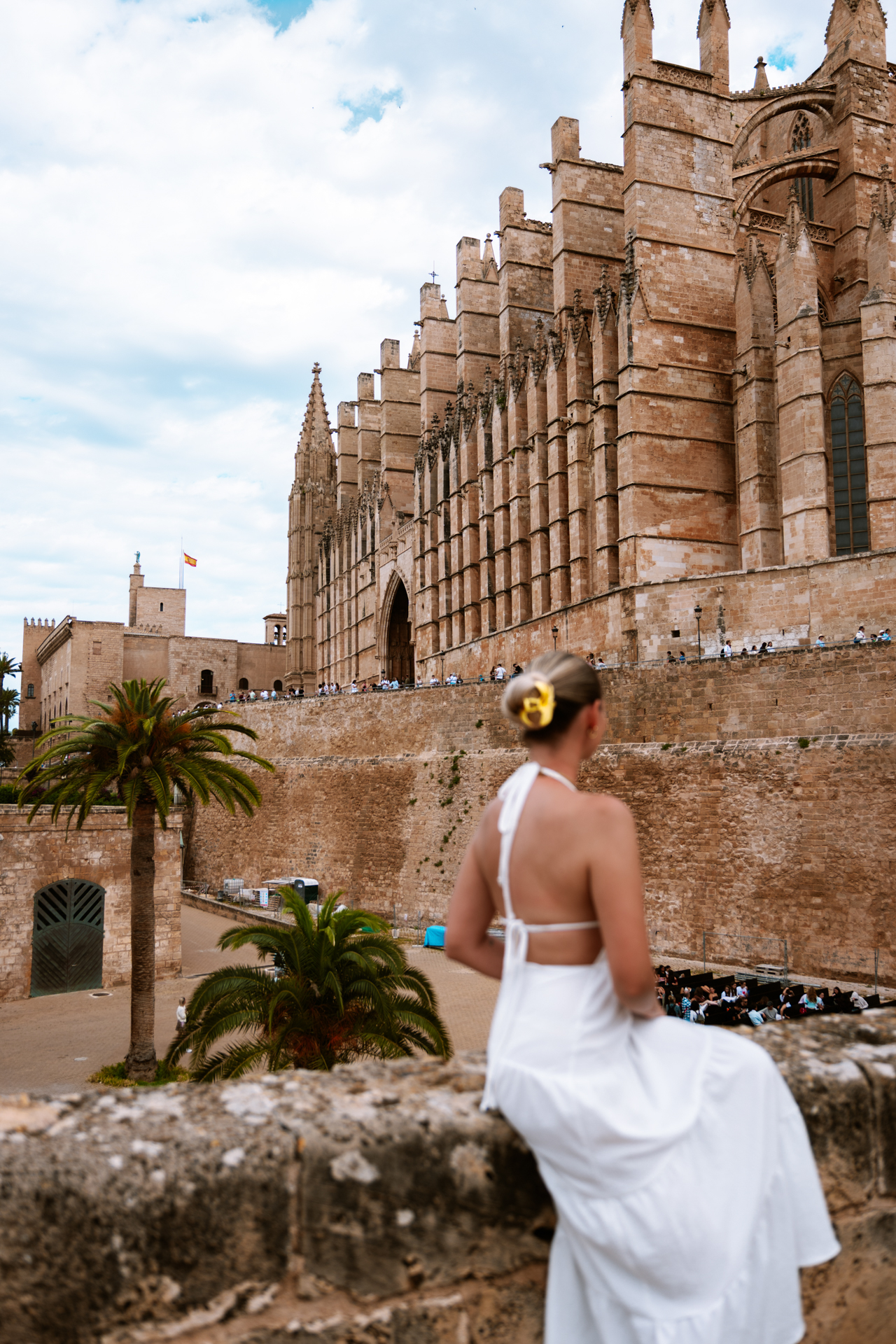 Woman in a white dress overlooking Palma Cathedral in Mallorca, Spain.