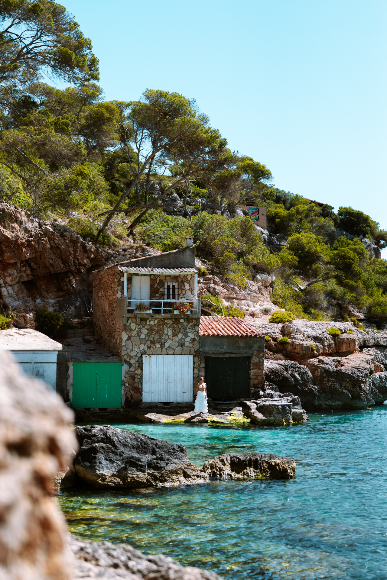Traditional boathouse on the rocky coast of Cala Llombards