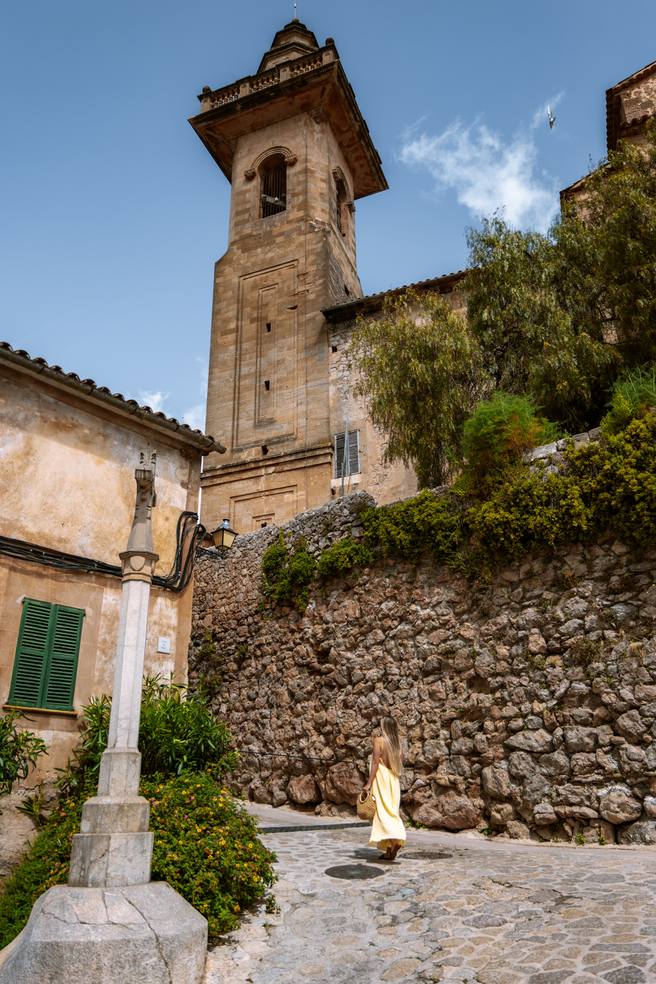 Woman walking beneath the church tower in Valldemossa, Mallorca