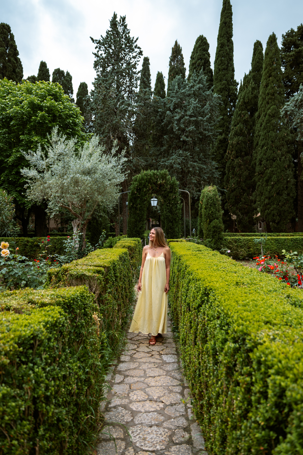 Woman walking through the gardens of Cartoixa de Valldemossa, Mallorca