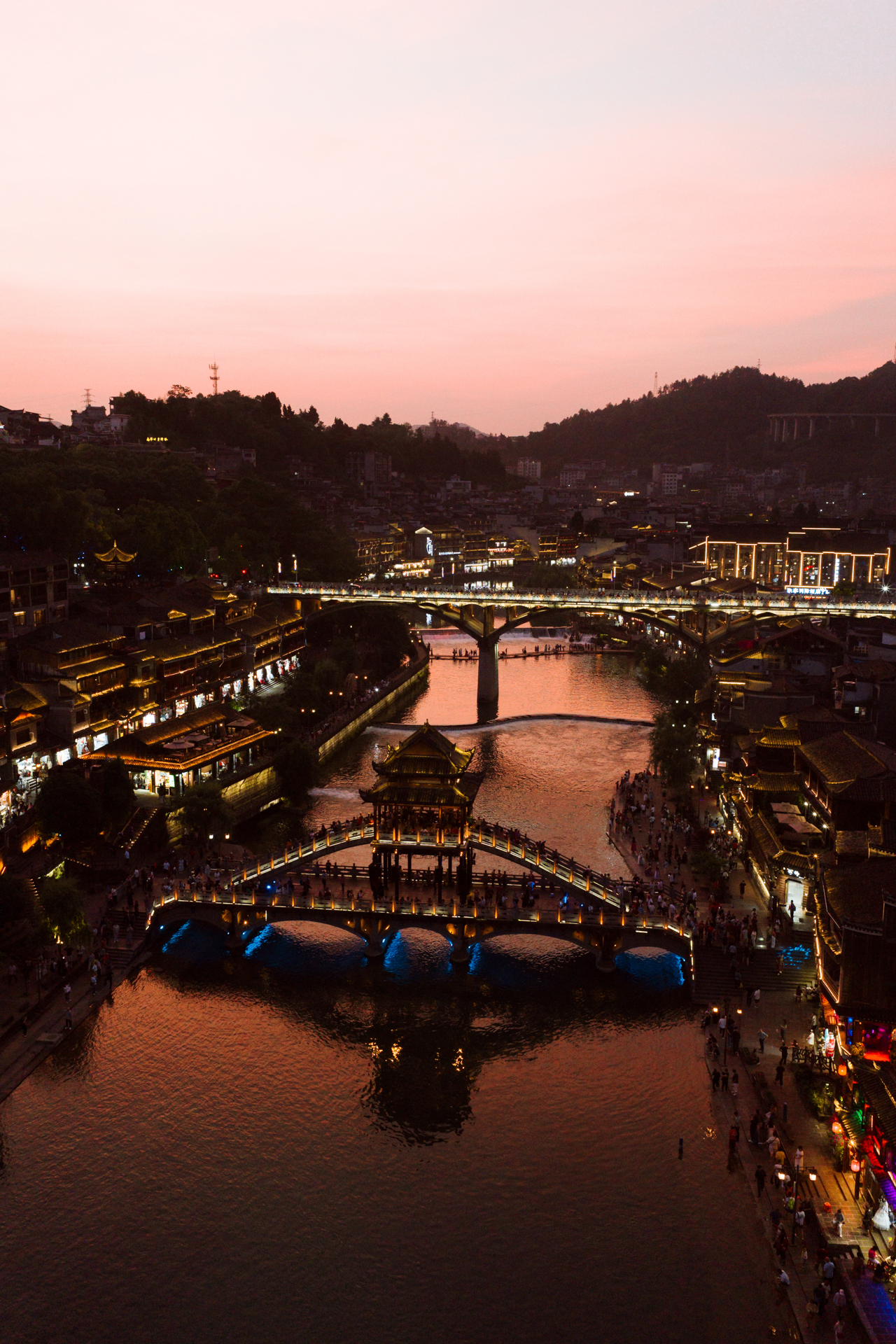 Fenghuang Ancient Town illuminated at sunset along the Tuojiang River, China