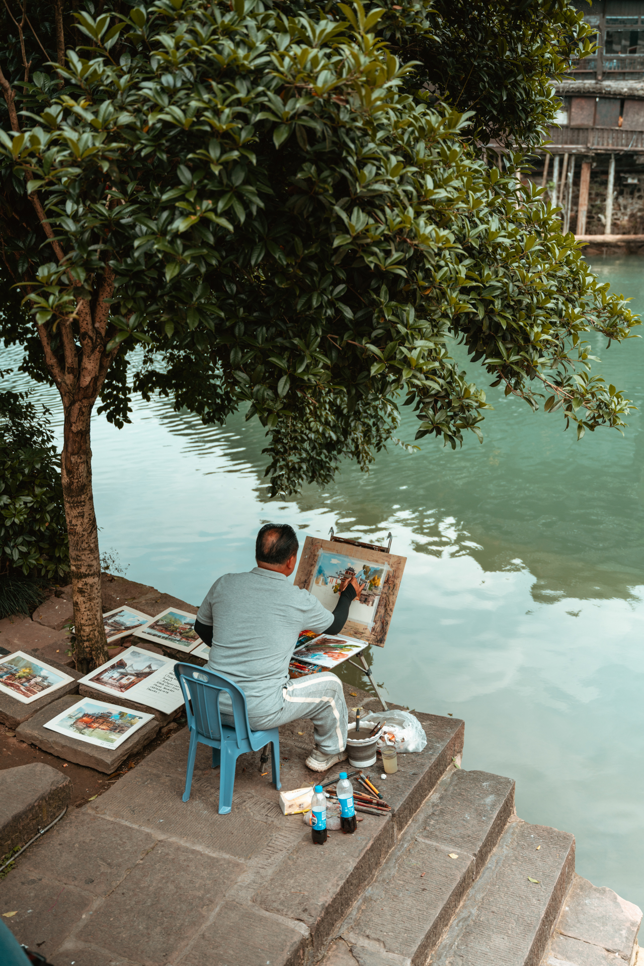 Local artist painting by the Tuojiang River in Fenghuang Ancient Town