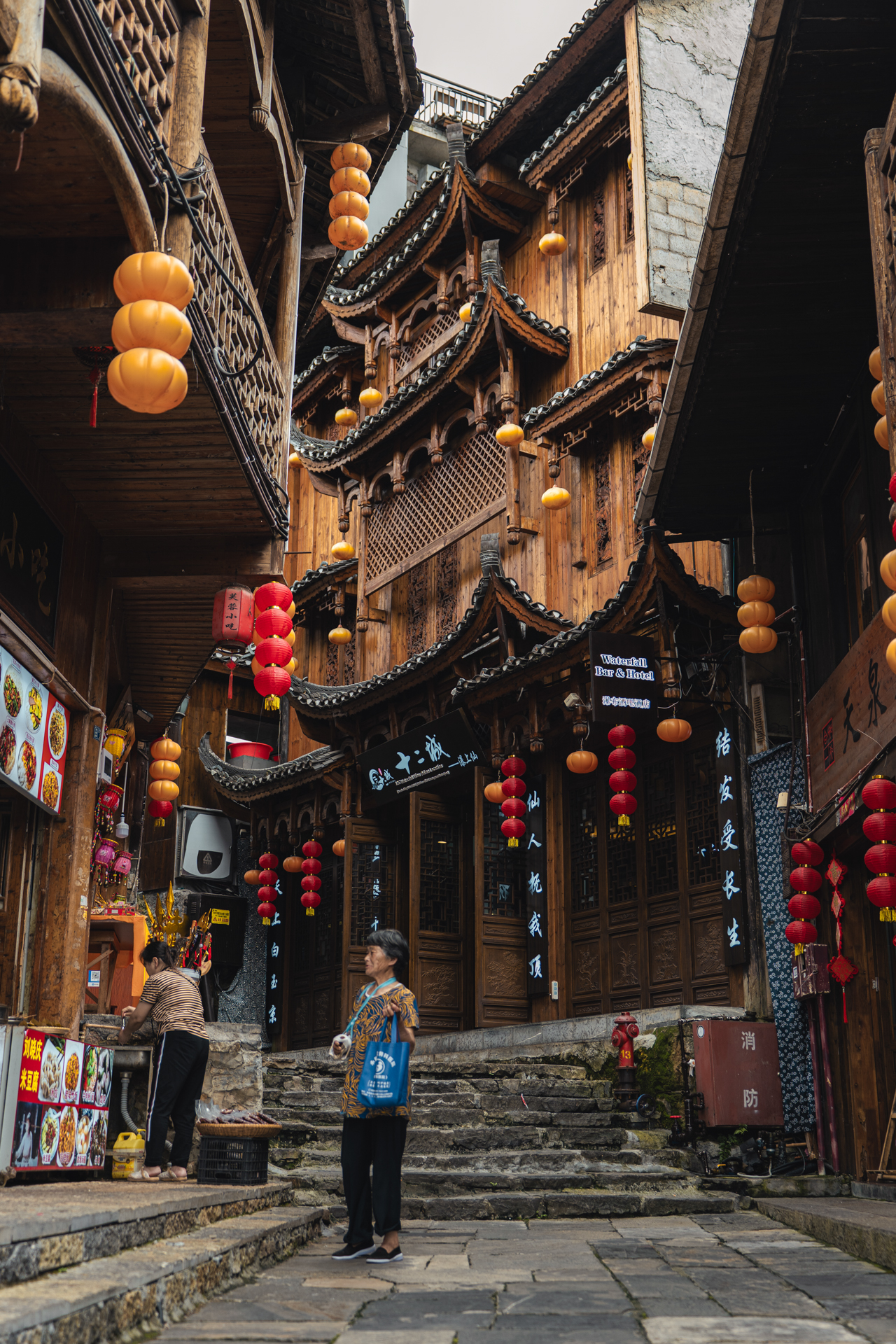 Narrow old street with wooden buildings and hanging lanterns in Furong Ancient Town.