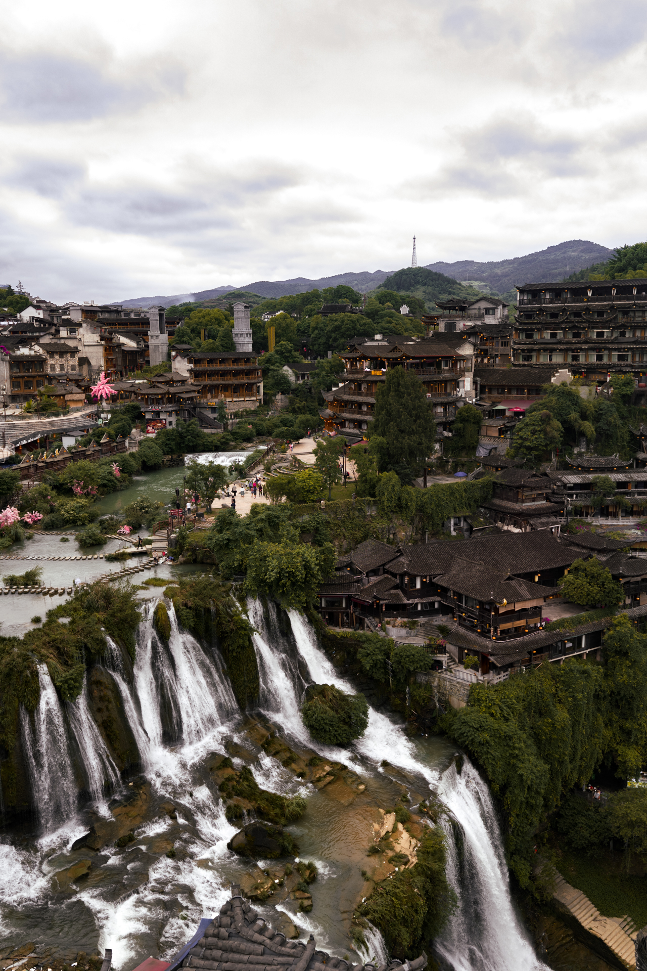 Aerial view of Furong Ancient Town and its cascading waterfall in Hunan, China.