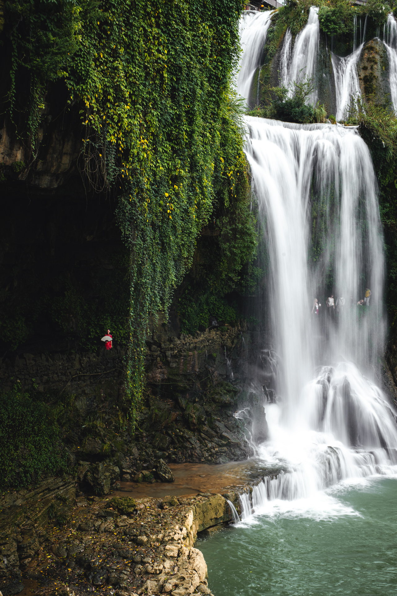 Furong Ancient Town waterfall surrounded by lush greenery in Hunan, China.