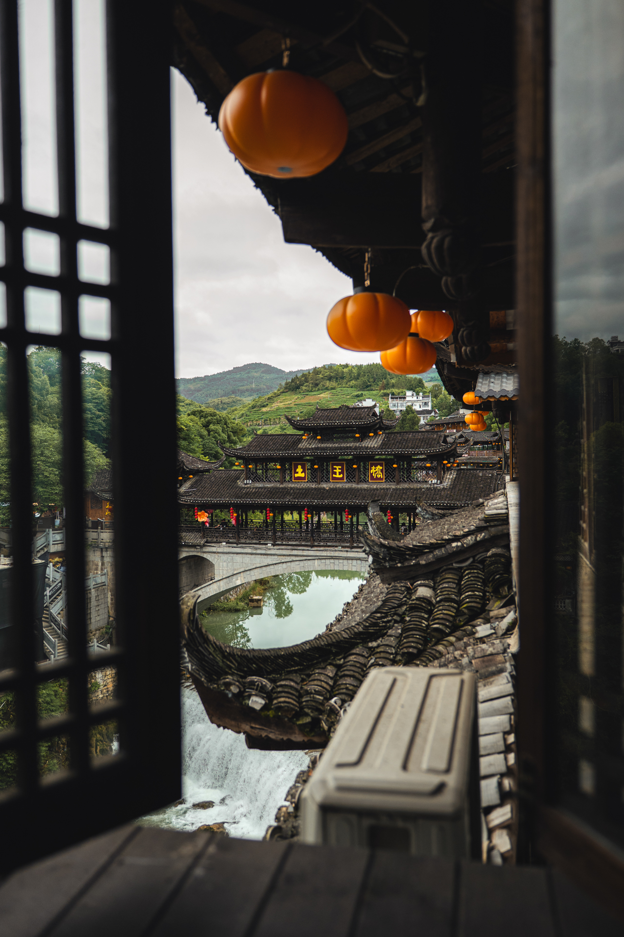 Traditional bridge and tiled rooftops in Furong Ancient Town, Hunan, China.