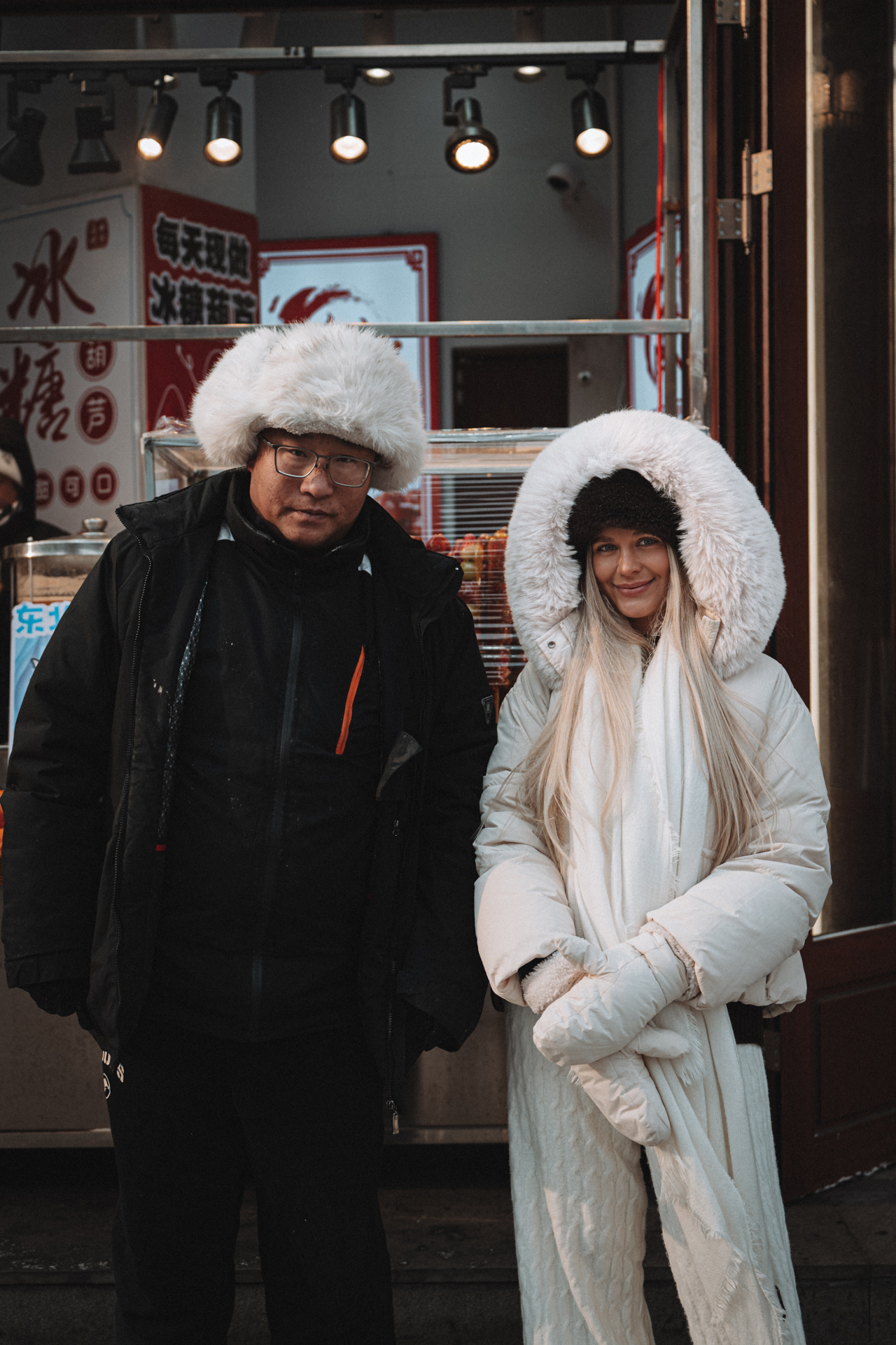Woman and local man dressed warmly for extreme winter weather in Harbin, China.
