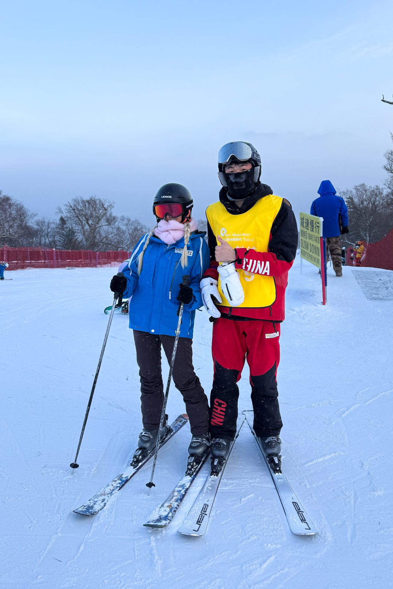 Skiing with an instructor at a snowy ski resort near Harbin, China.