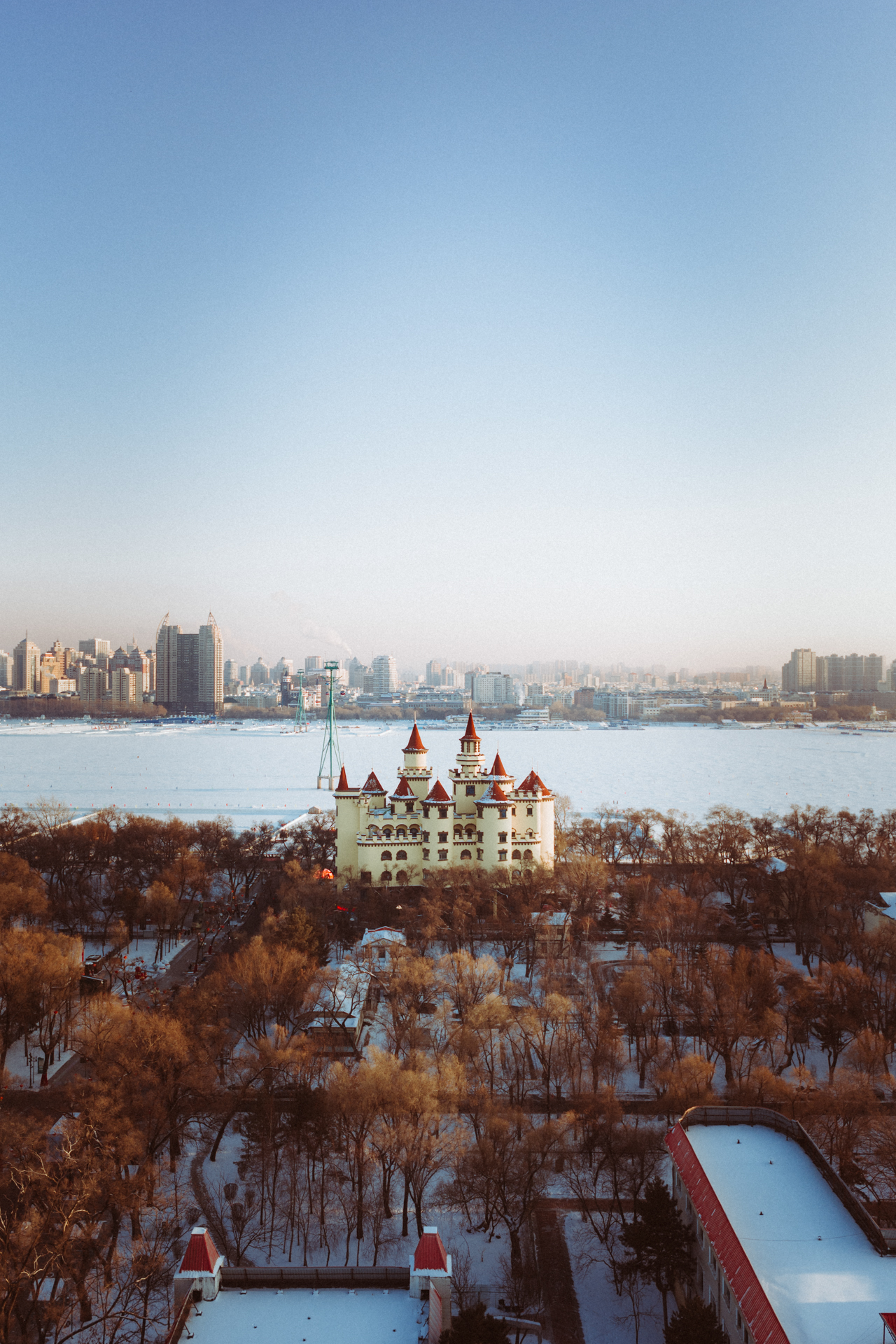 Winter view over Harbin with a snow-covered park, frozen river.
